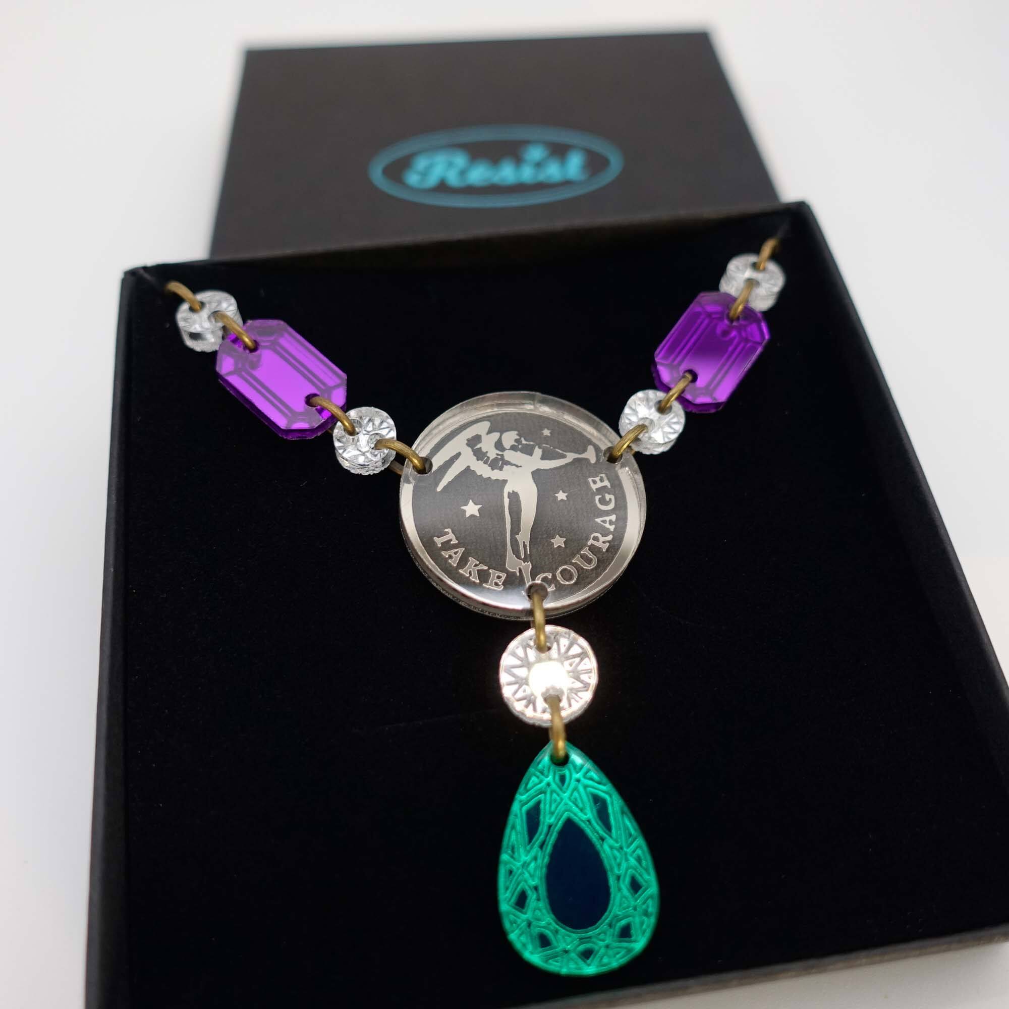 A close up of the Angel of Freedom necklace with the words Take Courage.
