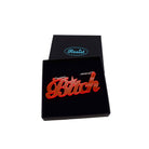 B*tch necklace in hot red shown in a Wear and Resist gift box. £2 goes to Bloody Good Period.
