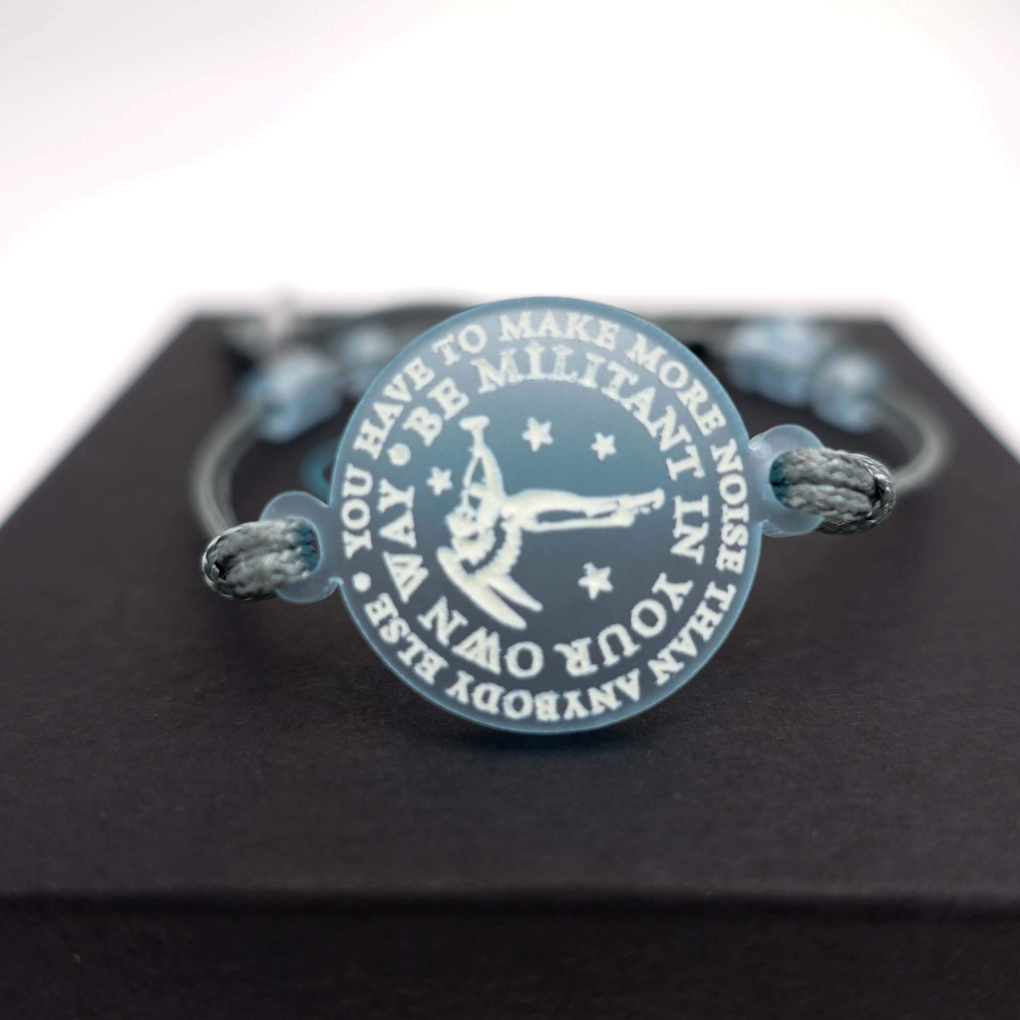 A close up of the bracelet with words of Emmeline Pankhurst etched in glow in the dark pigment around Sylvia Pankhurst's Angel of Freedom.