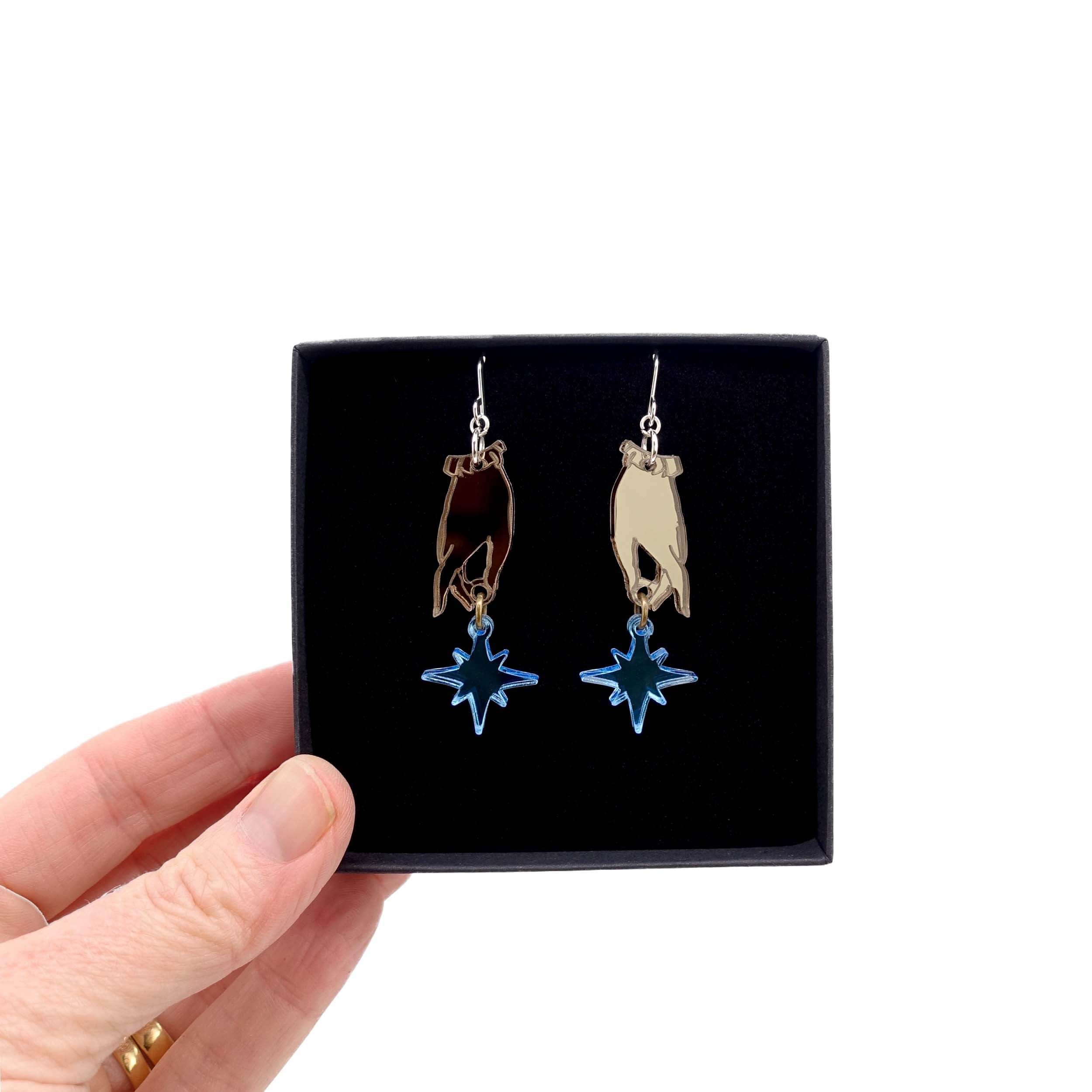 Dreams and Stars earrings from the Brontë Collection, designed by Sarah Day in collaboration with the Brontë Parsonage Museum, shown held up in a Wear and Resist gift box.