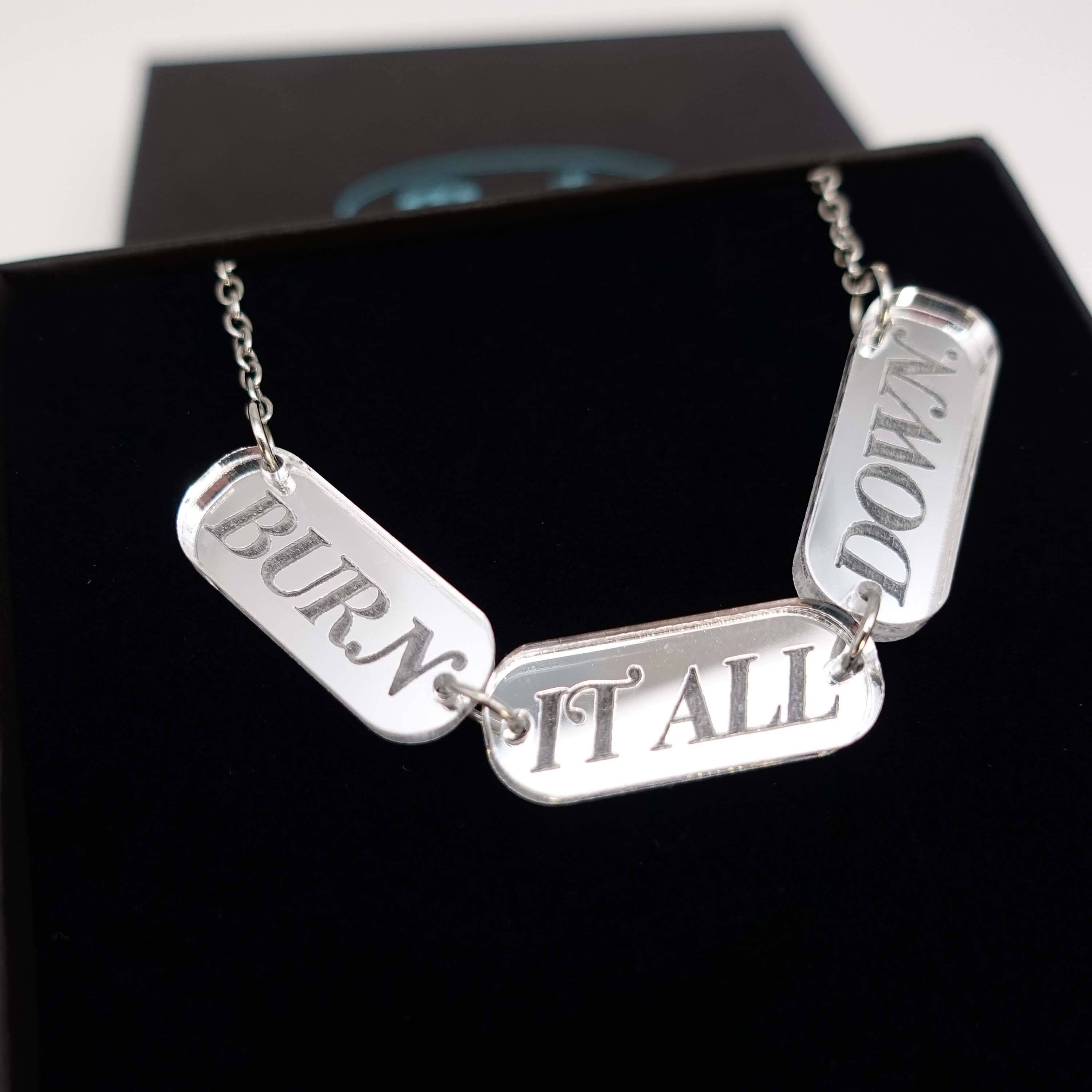 BURN IT ALL DOWN necklace in silver mirror on a stainless steel chain, shown close up in a Wear and Resist gift box.