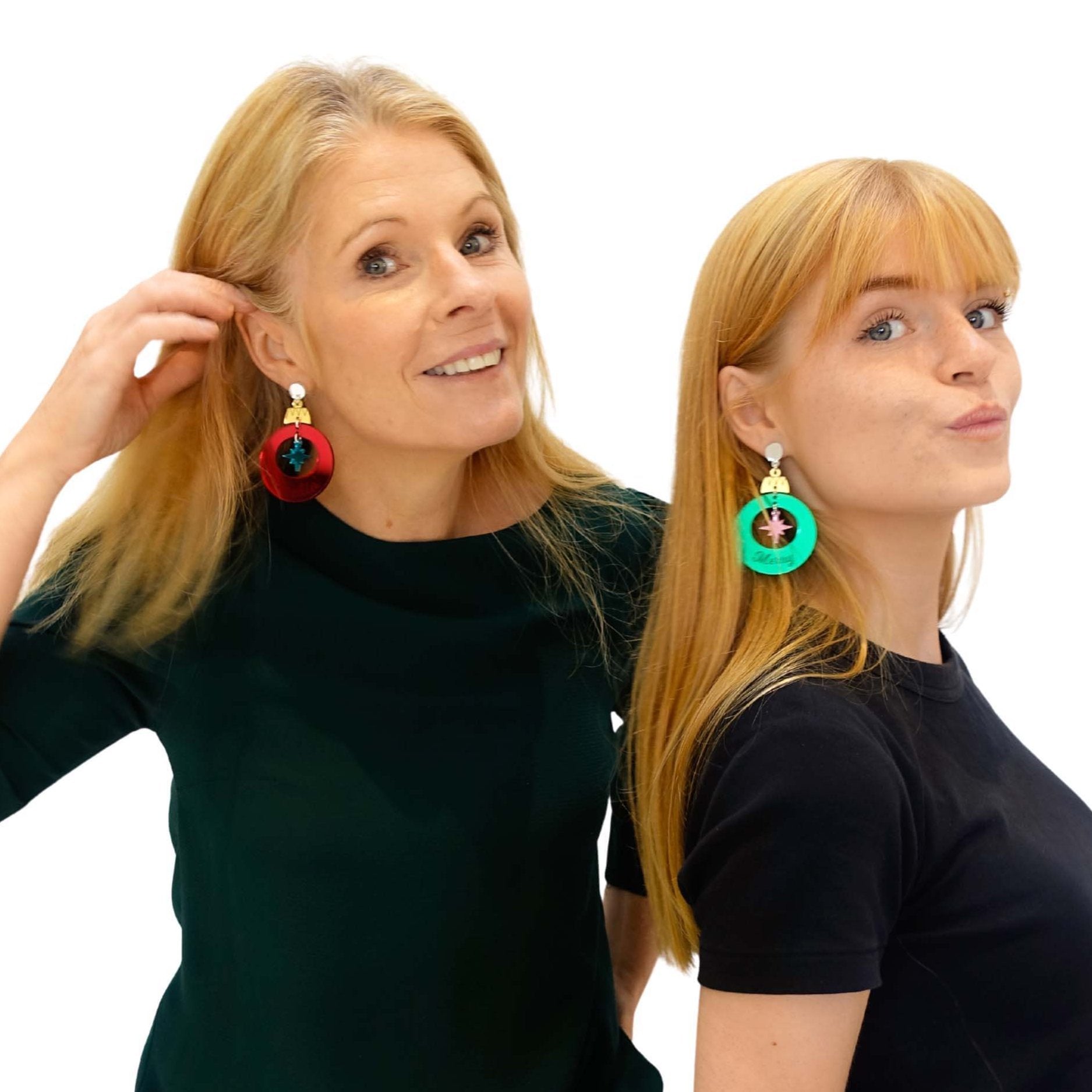 Sarah Day wears F*ckin Festive Christmas bauble earrings, while Eliza wears electric green Merry and Bright bauble earrings.