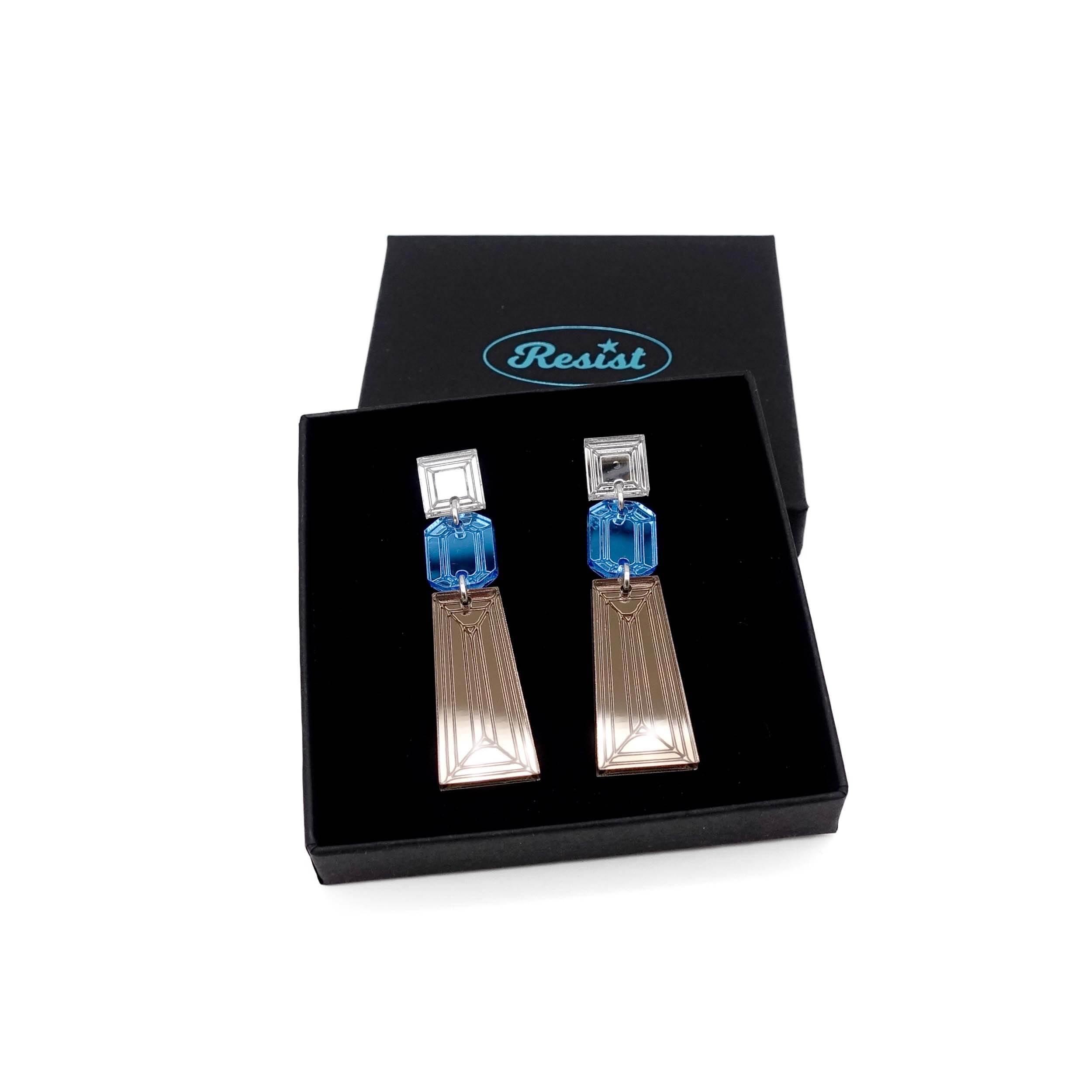 Long Deco drop earrings in bronze, sky and silver mirror shown in a Wear and Resist gift box. 