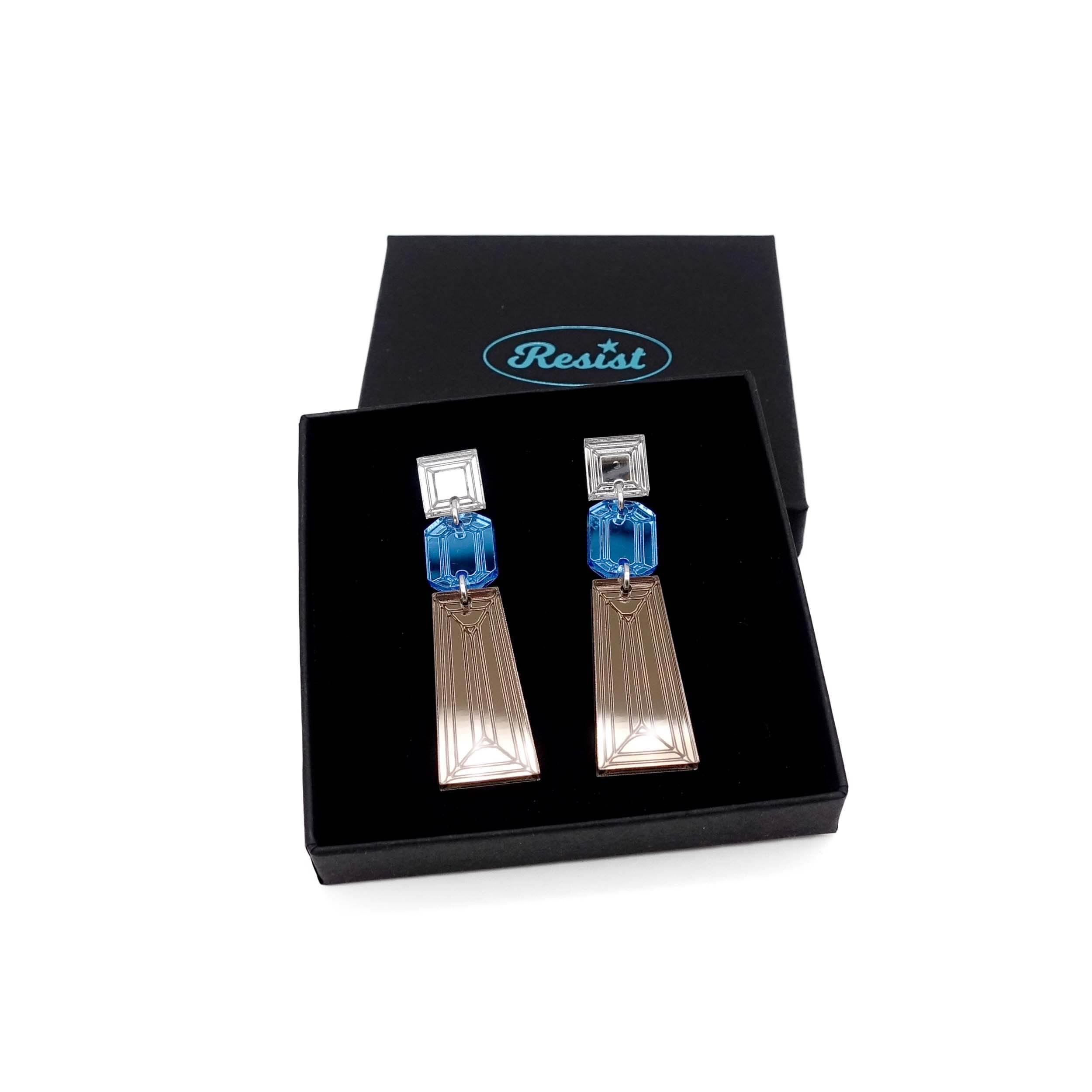 Long Deco drop earrings in bronze, sky and silver mirror shown in a Wear and Resist gift box.