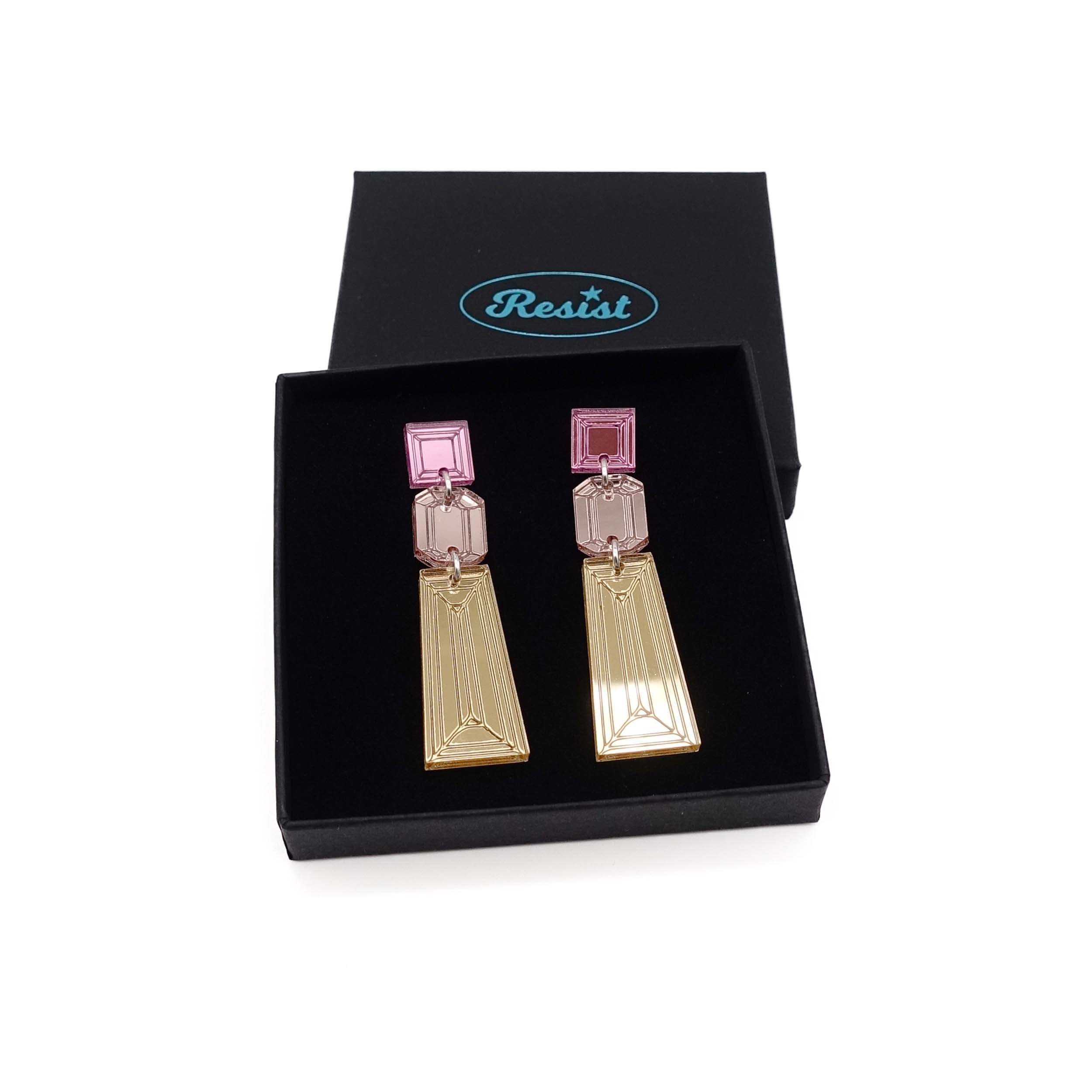 Long Deco drop earrings in gold, rose gold and pink mirror shown in a Wear and Resist gift box. 