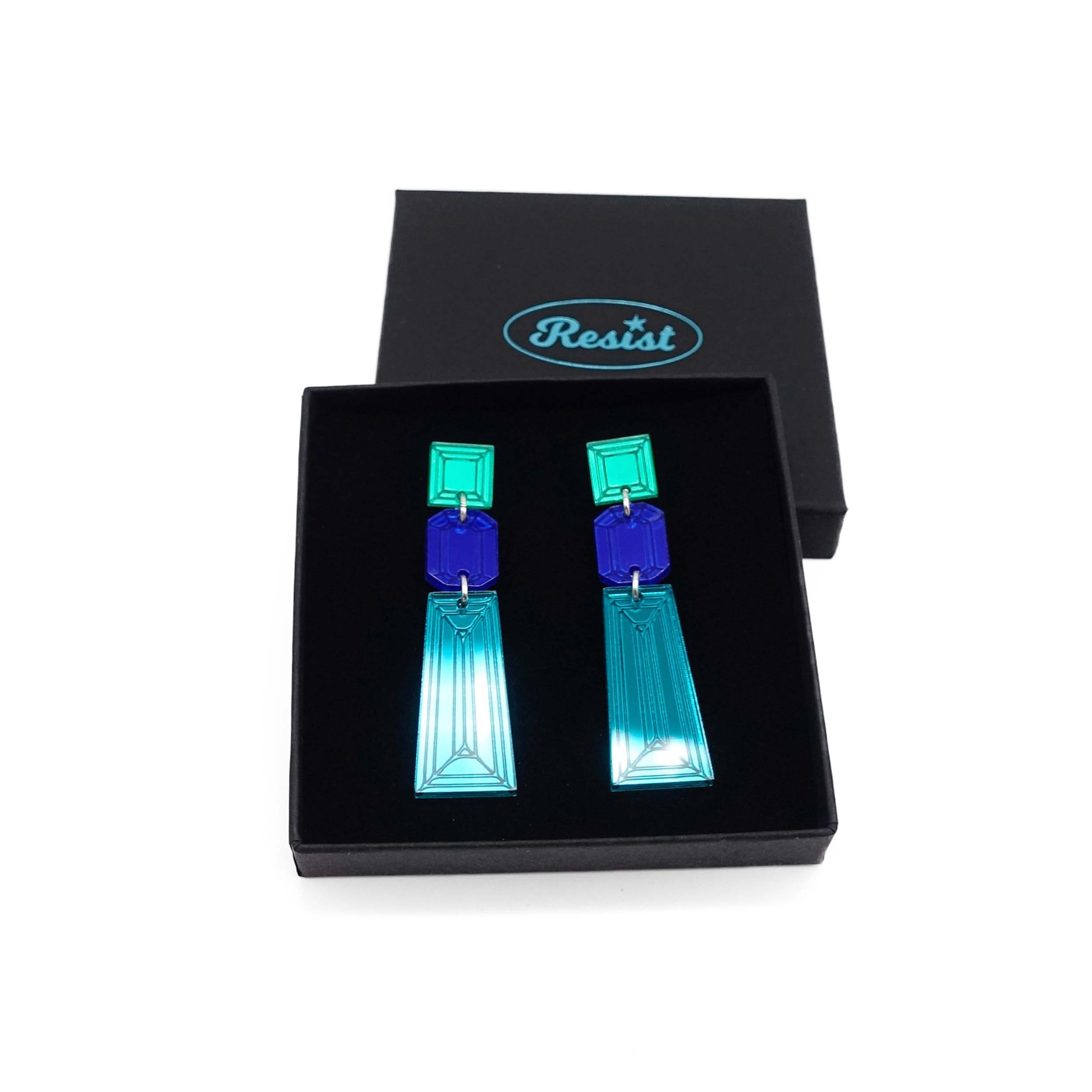 Long Deco drop earrings in teal, electric blue and electric green mirror shown in a Wear and Resist gift box.