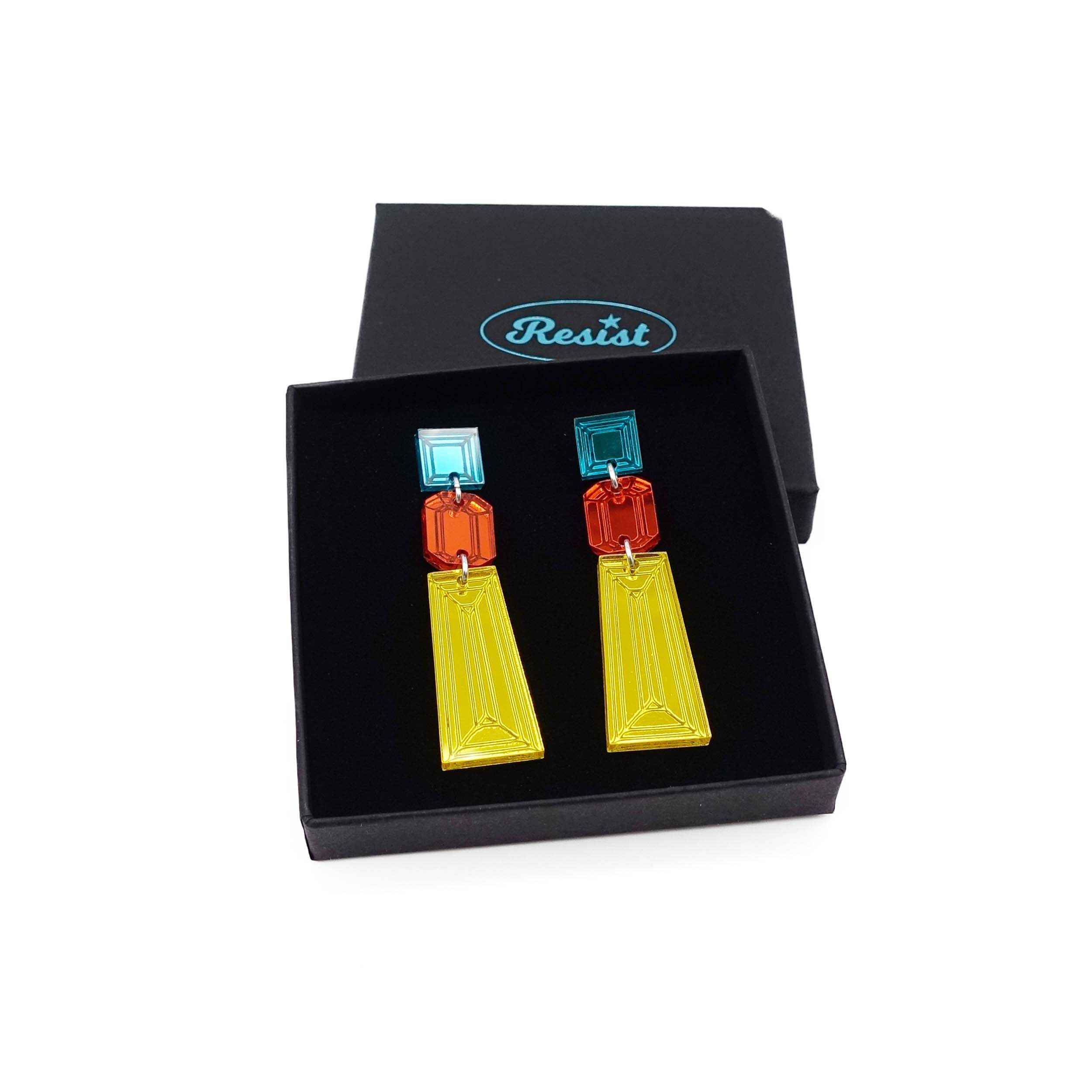 Long Deco drop earrings in yellow, flame and teal shown in a Wear and Resist gift box. 