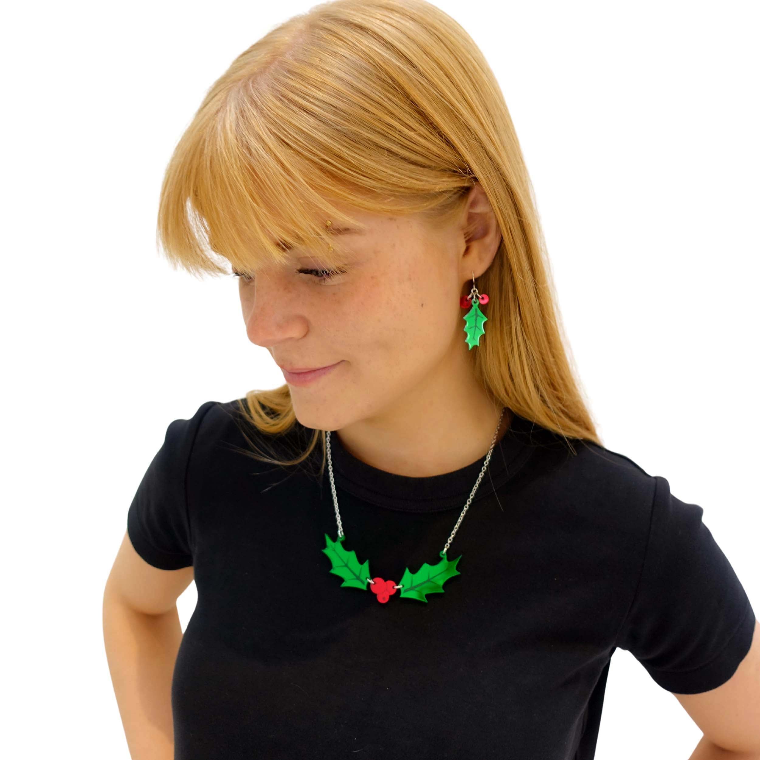 Eliza wears delicate holly earrings with matching Holly necklace.