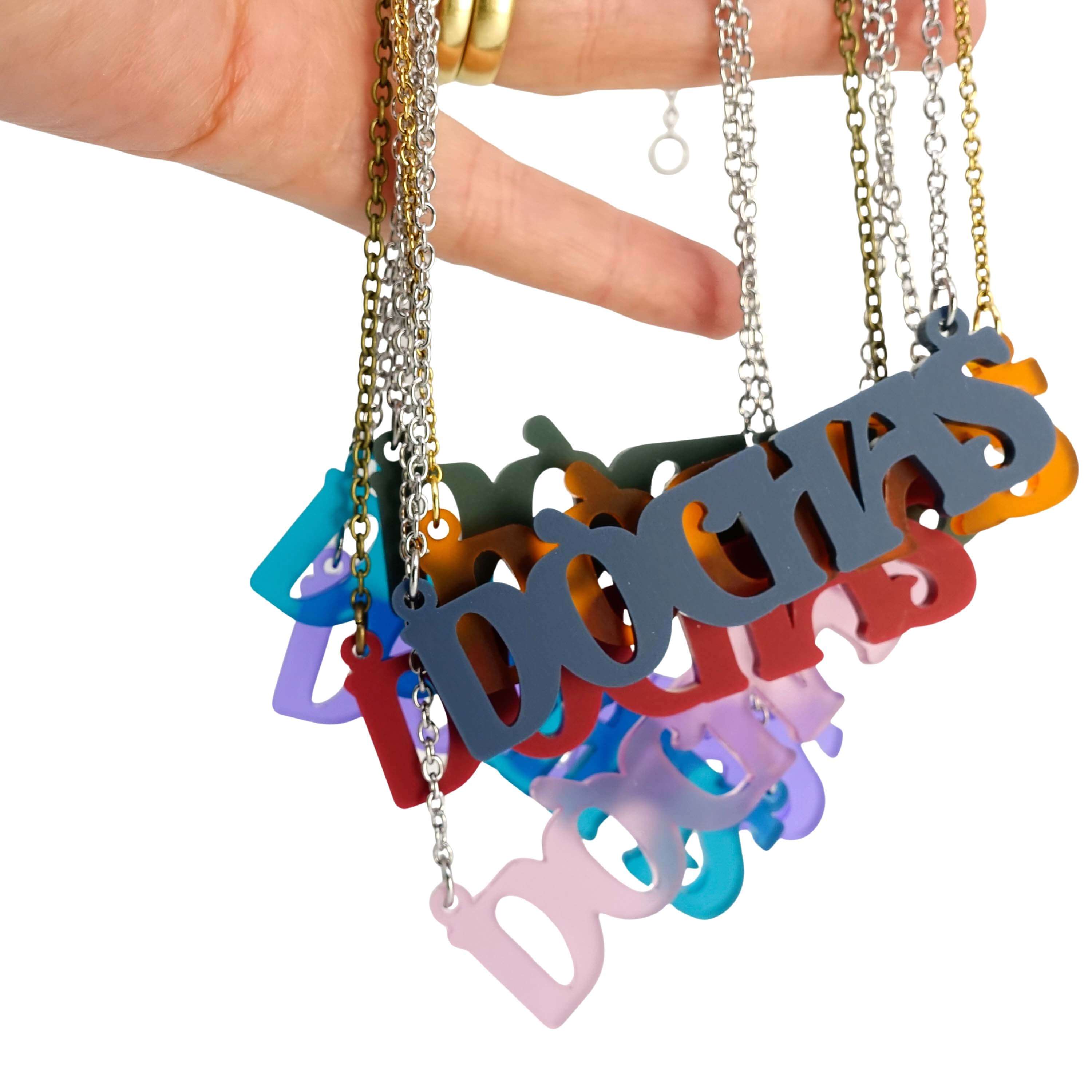 All of the colours of the DÒCHAS Irish Gaelige hope necklaces shown hanging together from my hand.