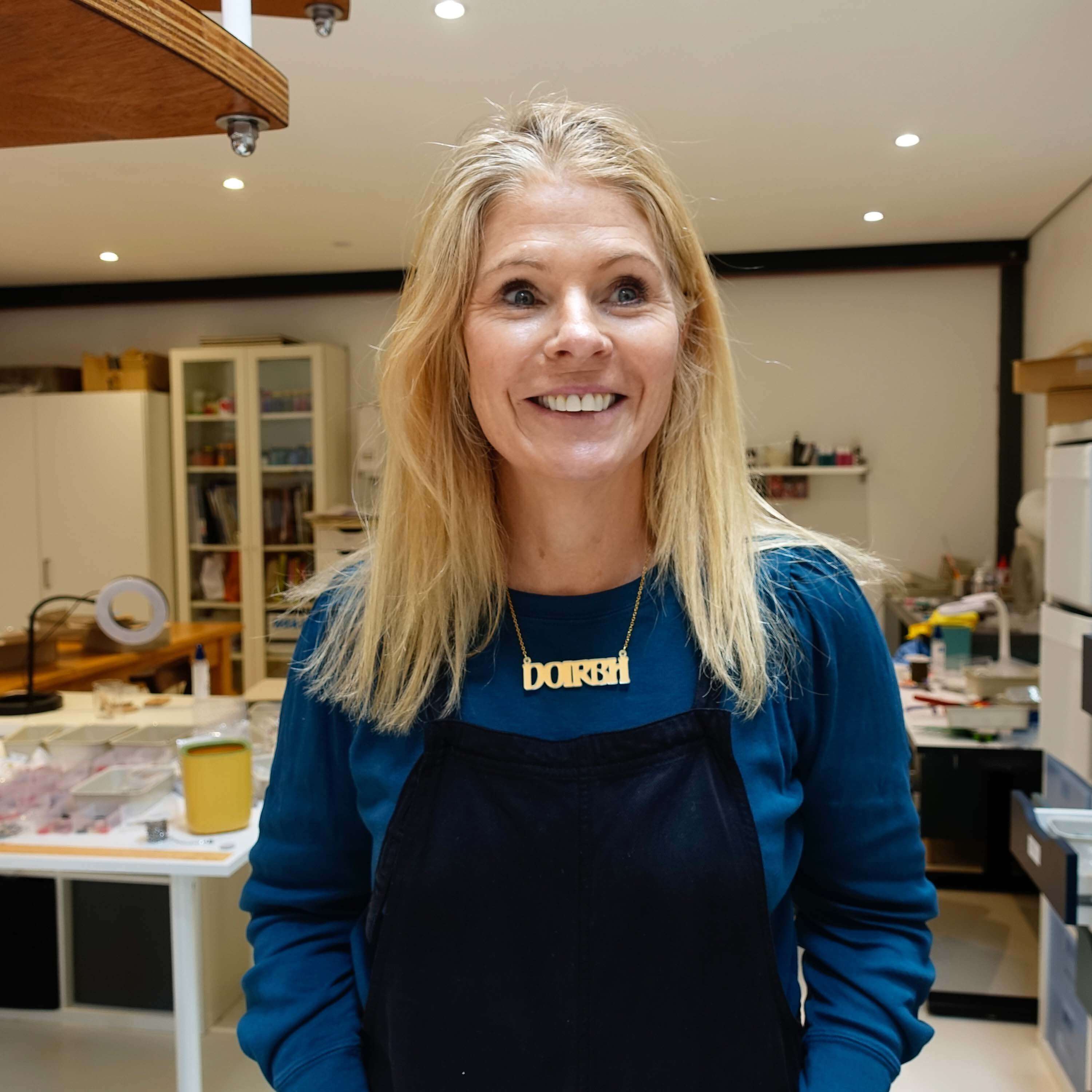 Sarah wears a DOIRBH Gaelige necklace for Irish difficult women in matte iridescent, in her studio.