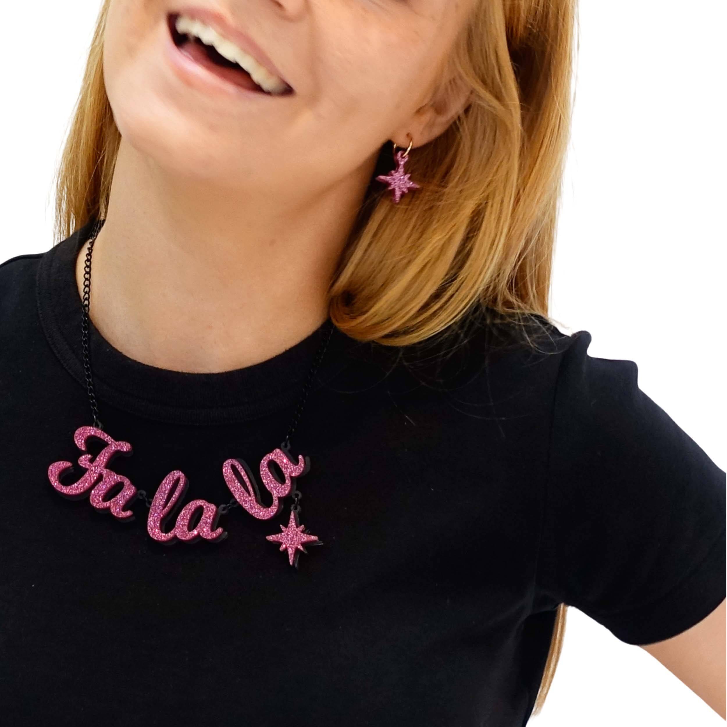 Eliza wears hot pink glitter festive Vintage Star hoop earrings with a matching Fa La La necklace from the Christmas Collection at Wear and Resist.
