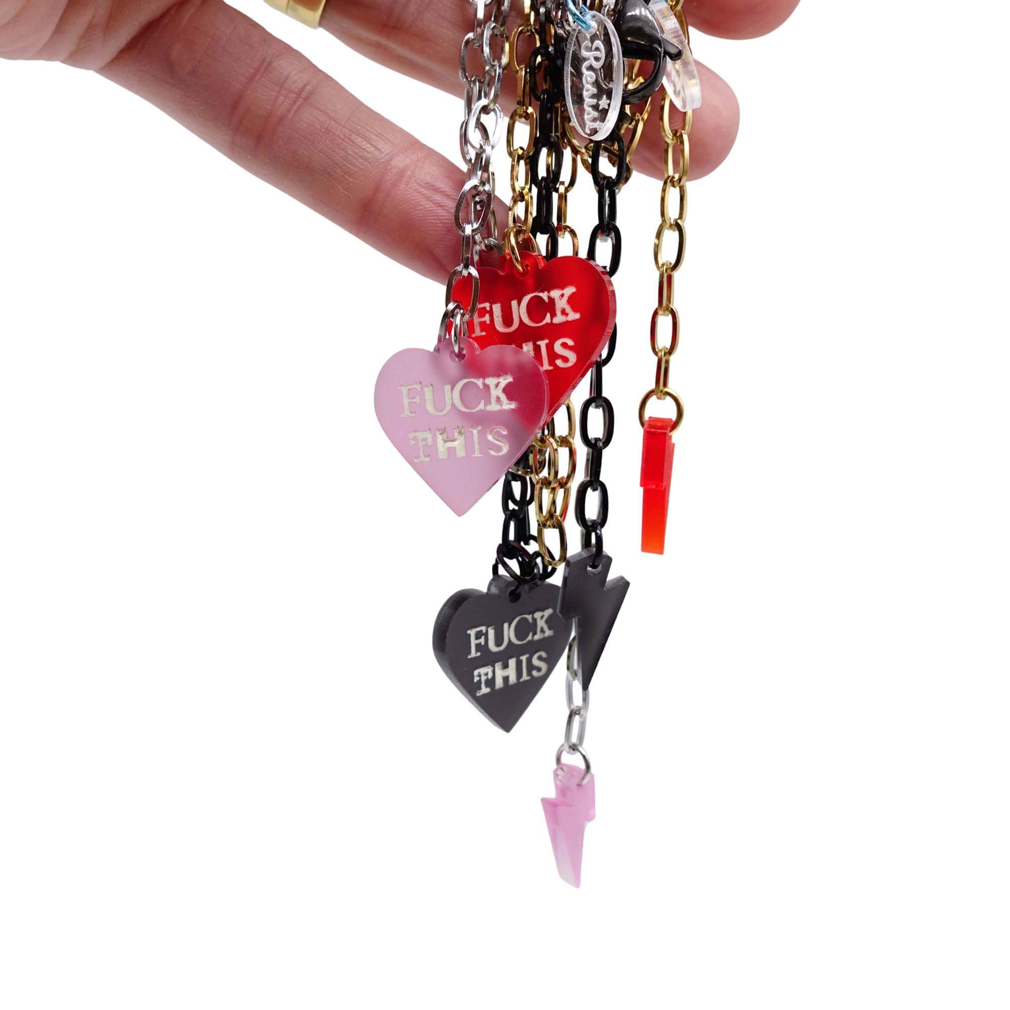 F*ck This punk necklaces shown held up in my hand against a white background.
