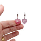 Pale pink frost F*ck This huggie hoop earrings shown with my hand for scale. they glow in the dark!