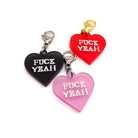 Heart charms in chilli frost, pink frost and slate frost etched in glow-in-the-dark pigment with the words 'F*ck Yeah'