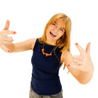 Eliza wears a F*ck Yeah necklace in day-glo orange.