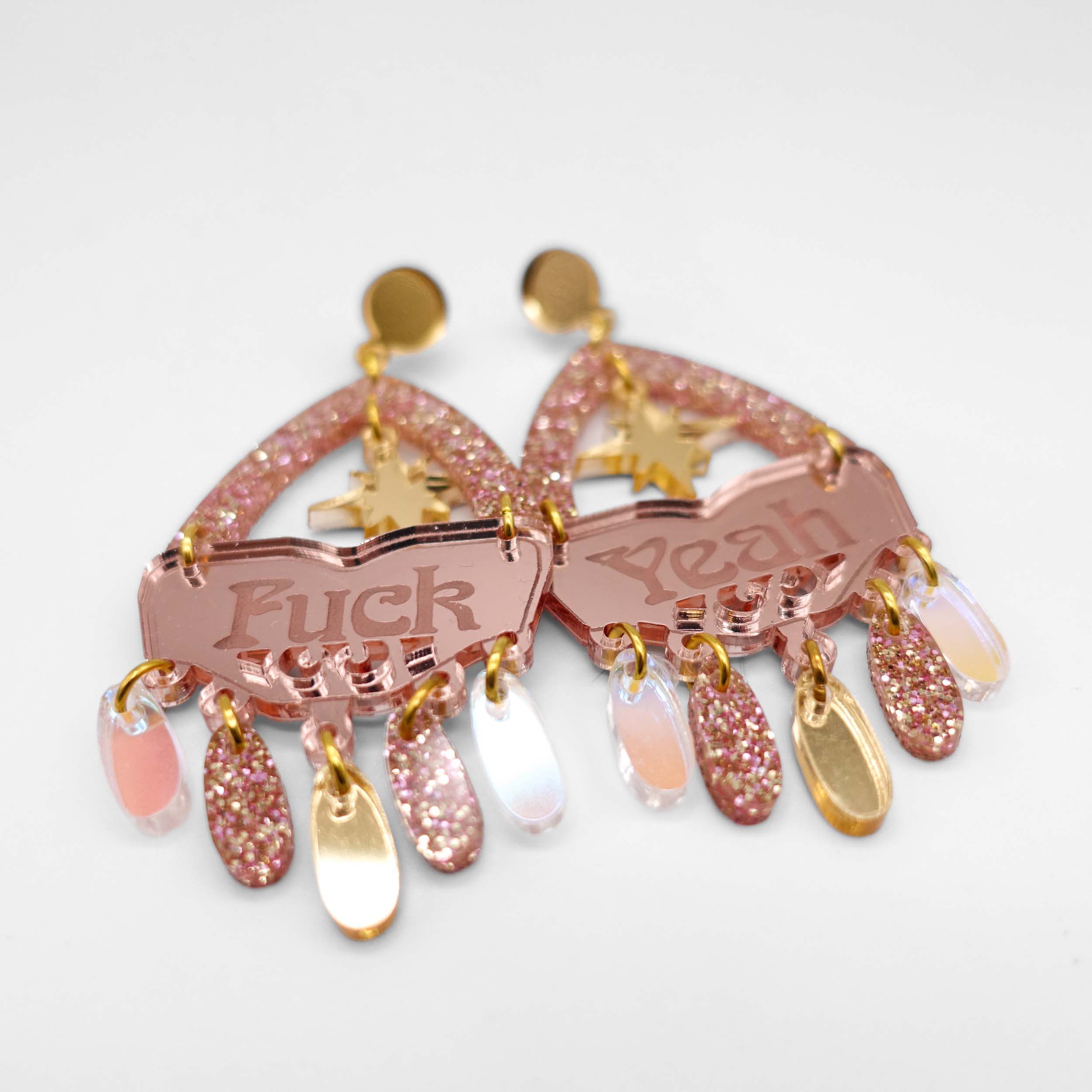 A close up of the F*ck Yeah statement earrings in rosey gold colourway.