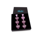 F*ck this Sh*t earrings in pale pink frost with glow-in-the-dark words shown in a Wear and Resist gift box.