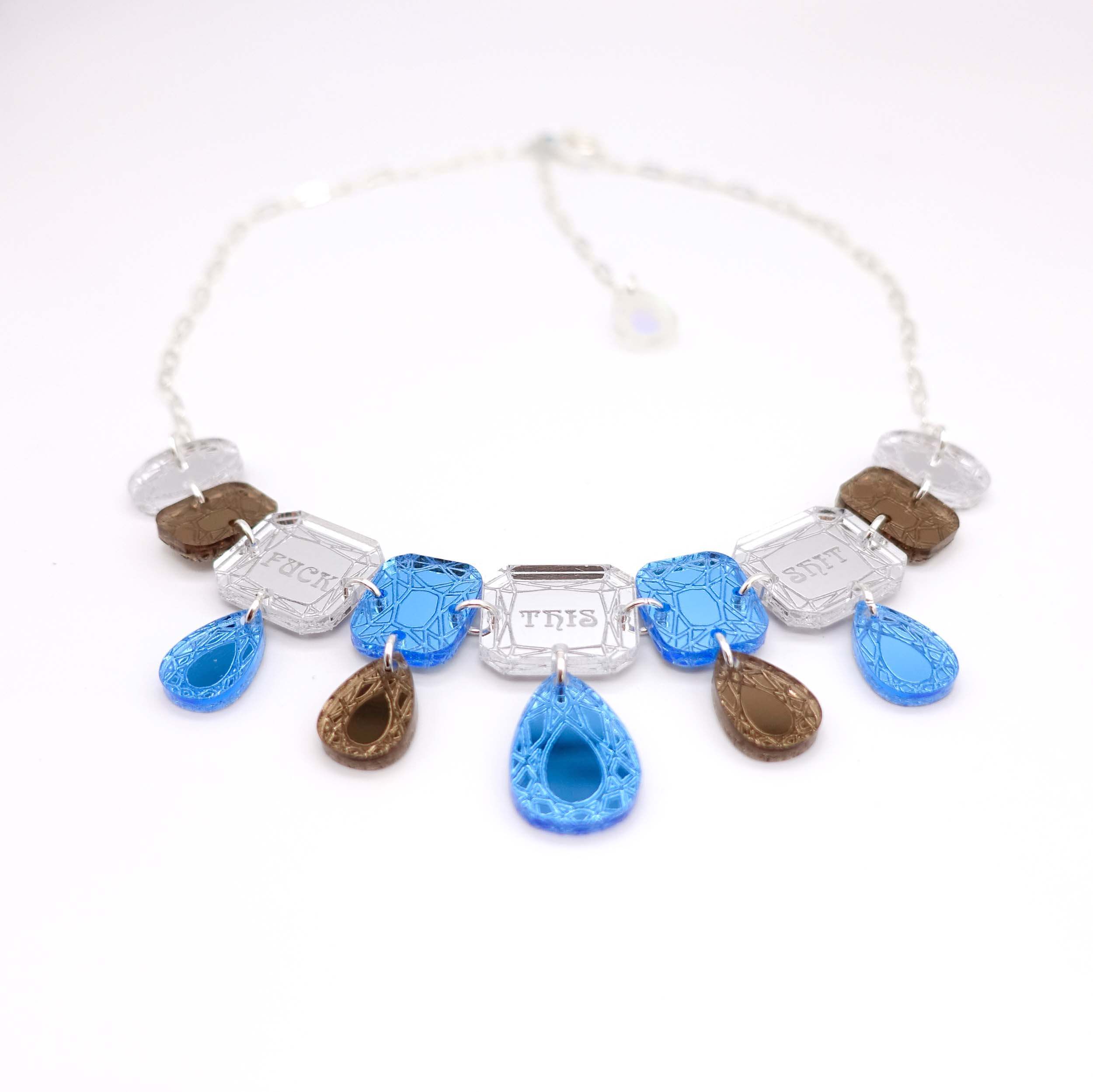 F*ck This Sh*t Jewel necklace in blue shown laying on a white surface.