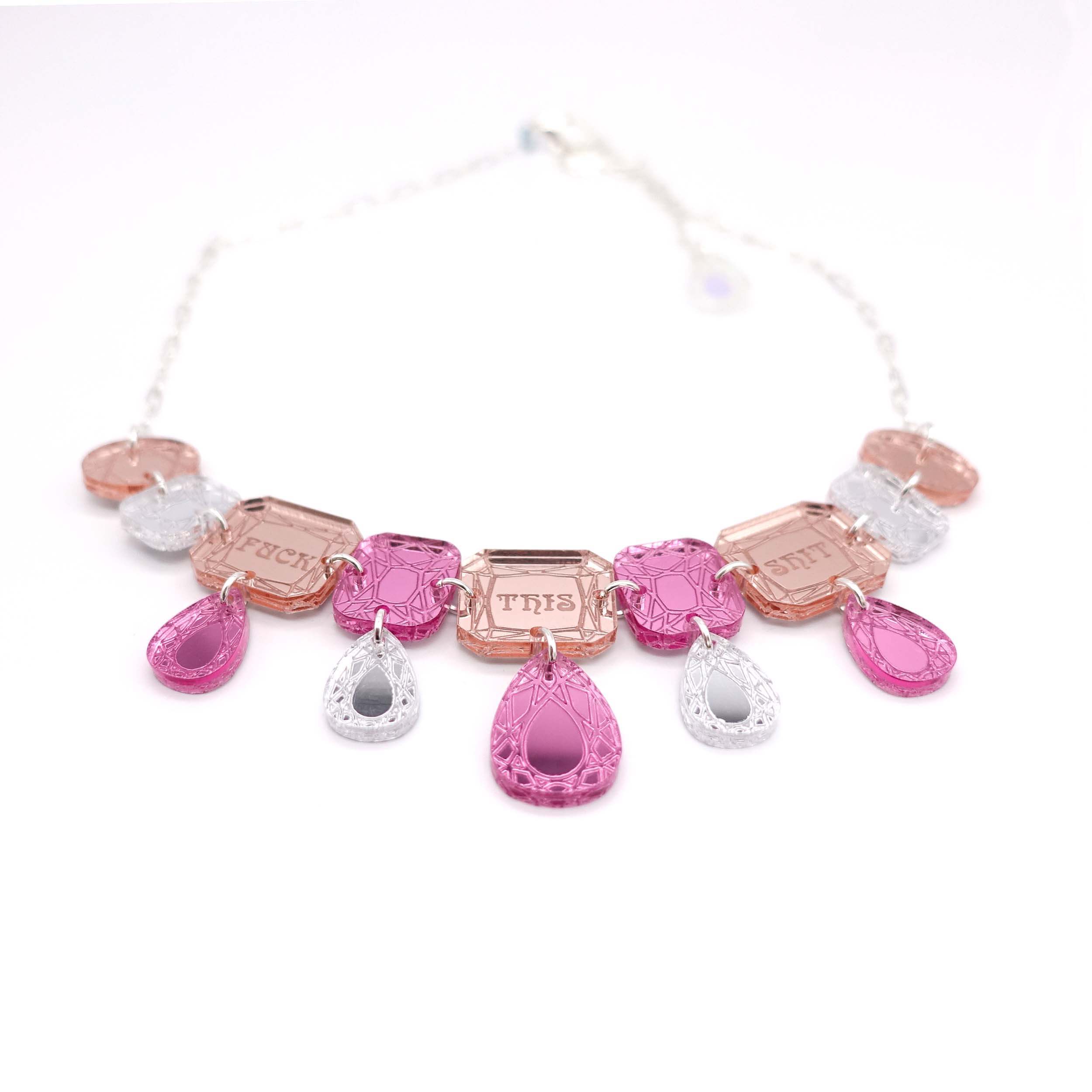 F*ck This Sh*t Jewel necklace in pink shown laying on a white surface. £2 goes to Bloody Good Period charity.