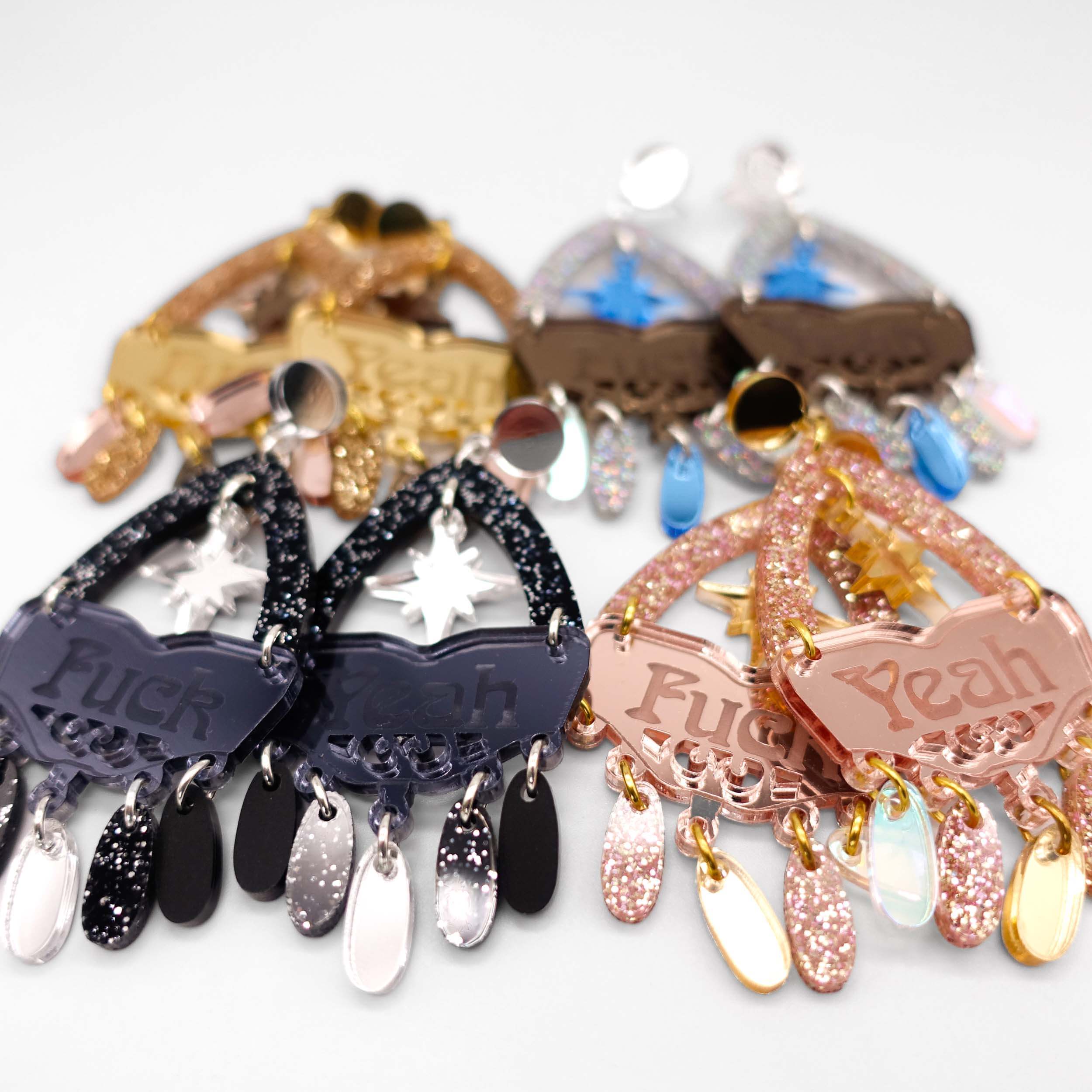 A close up of all four colourways of the F*ck Yeah statement earrings.