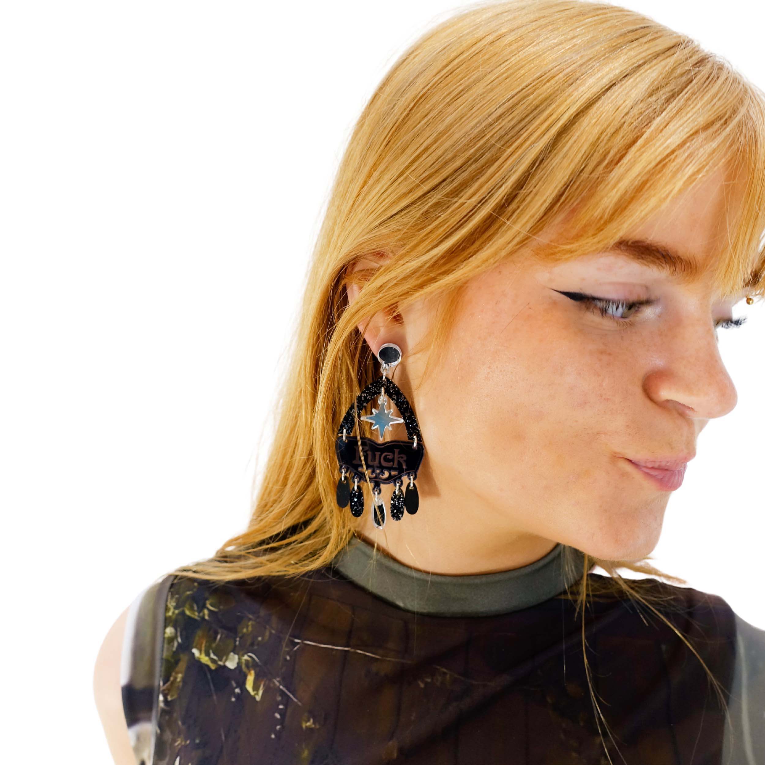 Eliza wears the F*ck Yeah statement earrings in midnight colourway.