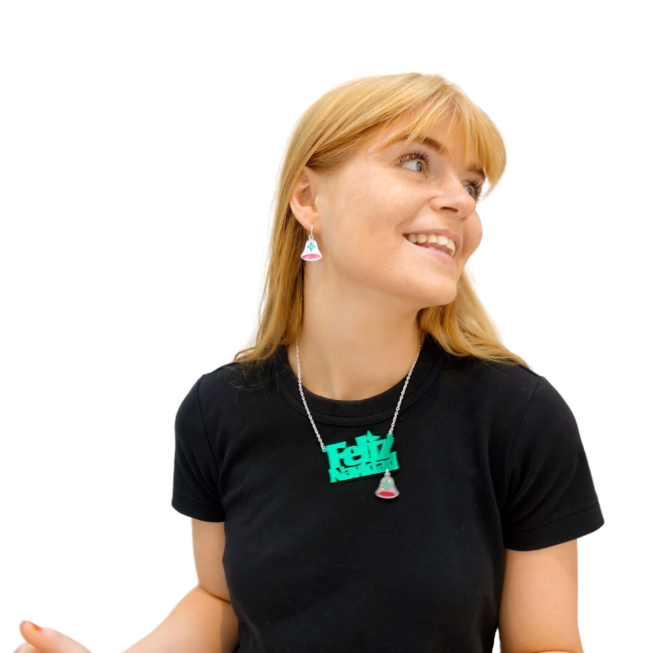 Eliza wears the Feliz Navidad necklace in electric green and matching Glitter Bell earrings.