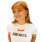 Eliza wears a script font Feminist necklace in fluoro orange with matte iridescent vintage star earrings.