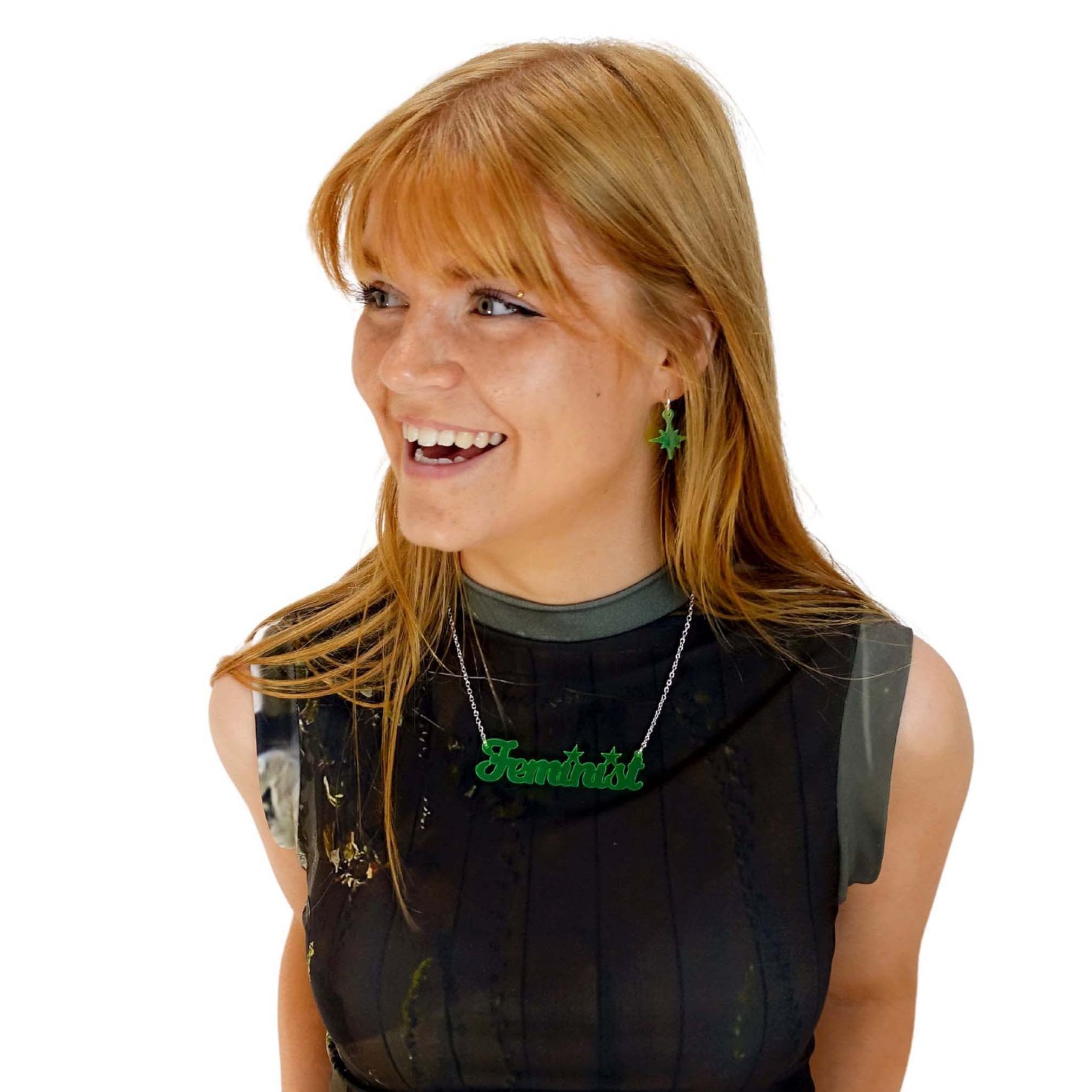 Eliza wears a script font Feminist necklace in neon lime with matching Vintage Star earrings.