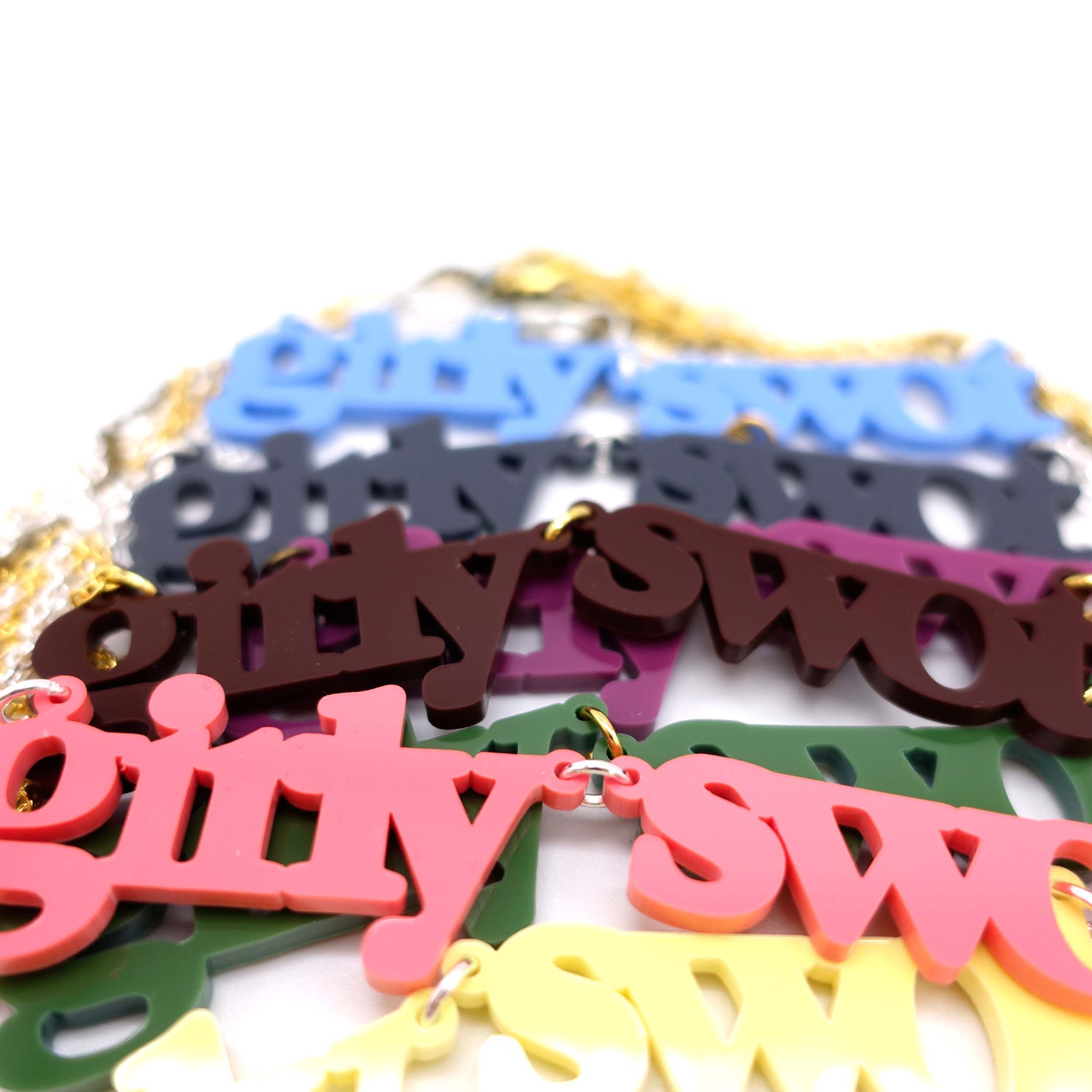A close up of the different colours of Girly Swot necklaces