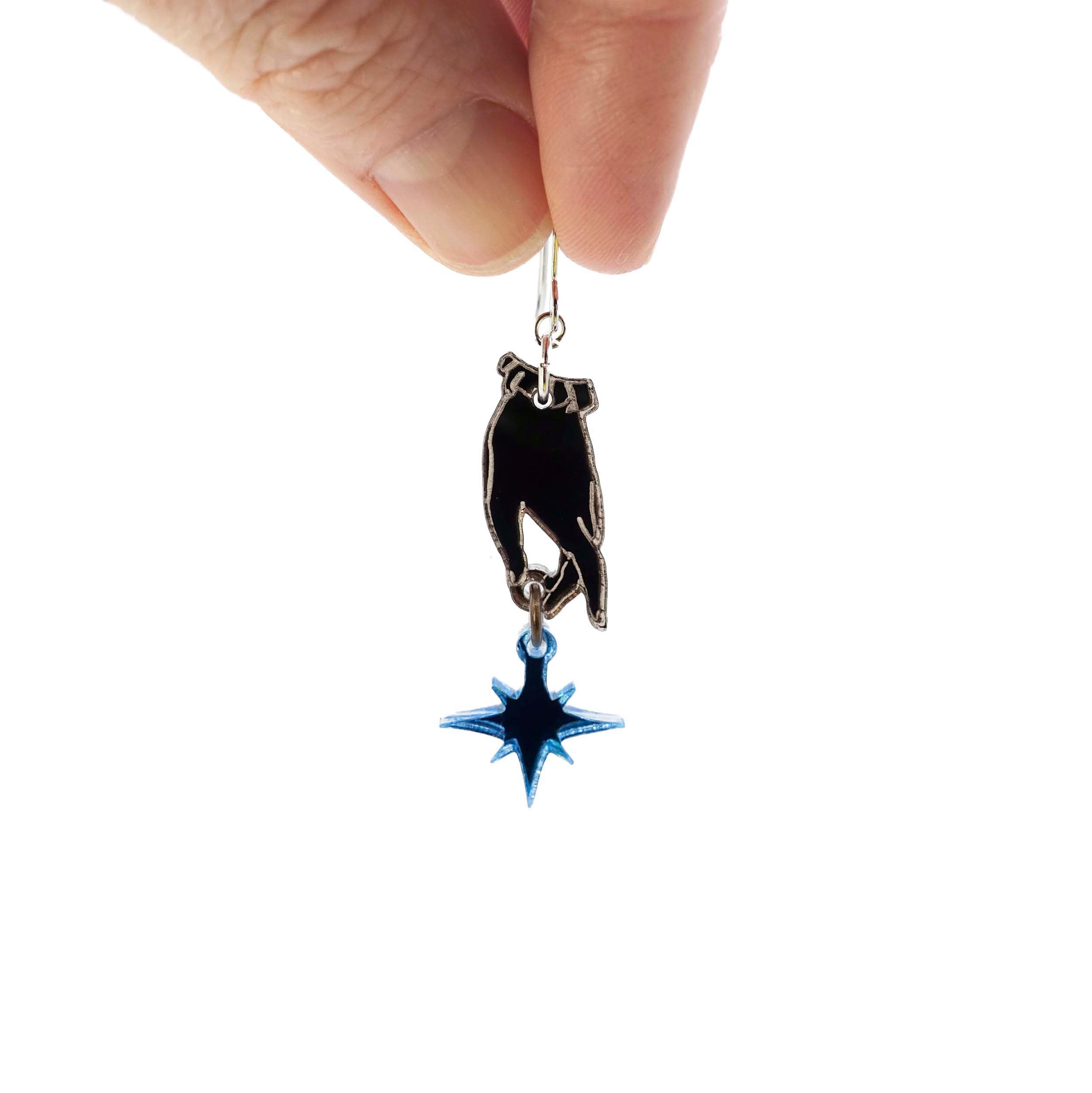 A hand holds a Dreams and Stars earring from the Brontë Collection, designed by Sarah Day in collaboration with the Brontë Parsonage Museum.