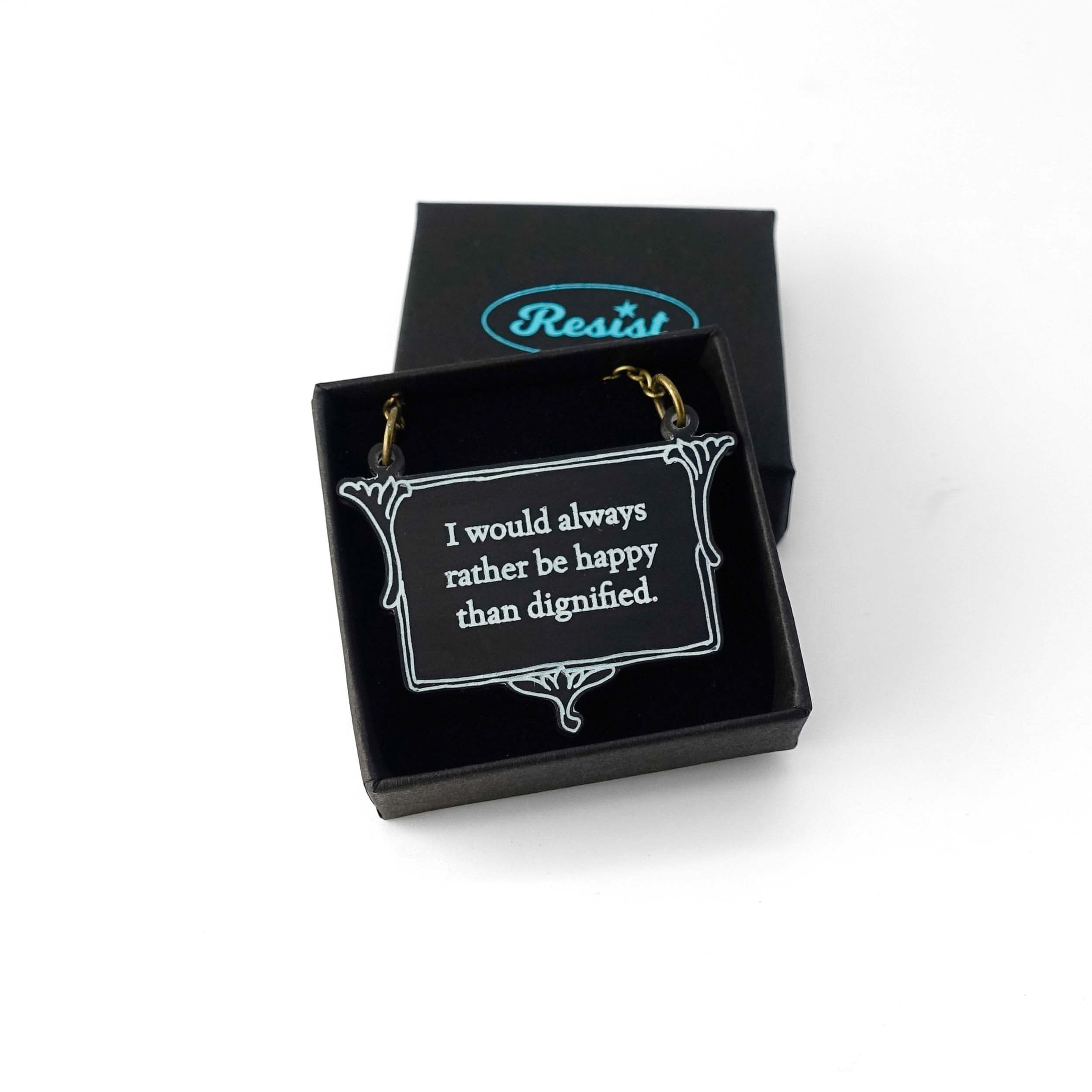 A vintage style slate necklace etched with the words of Jane Eyre 'I would always rather be happy than dignified', shown in a small Wear and Resist gift box.