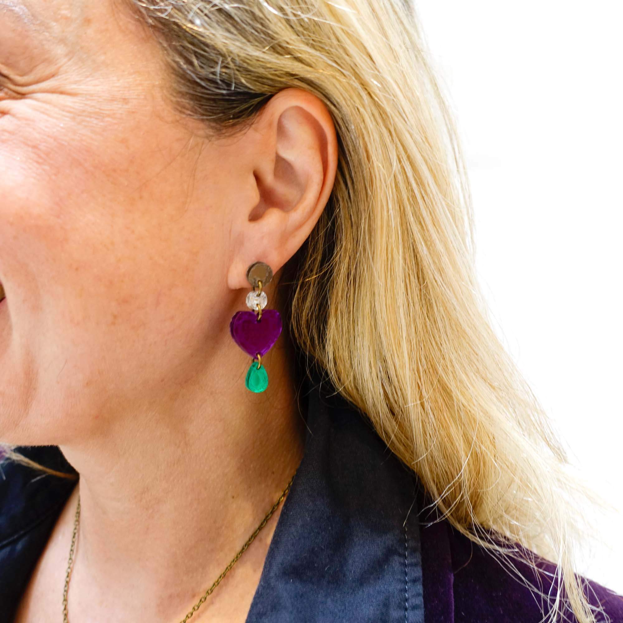 Andrea wears the purple suffragette heart drop earrings.