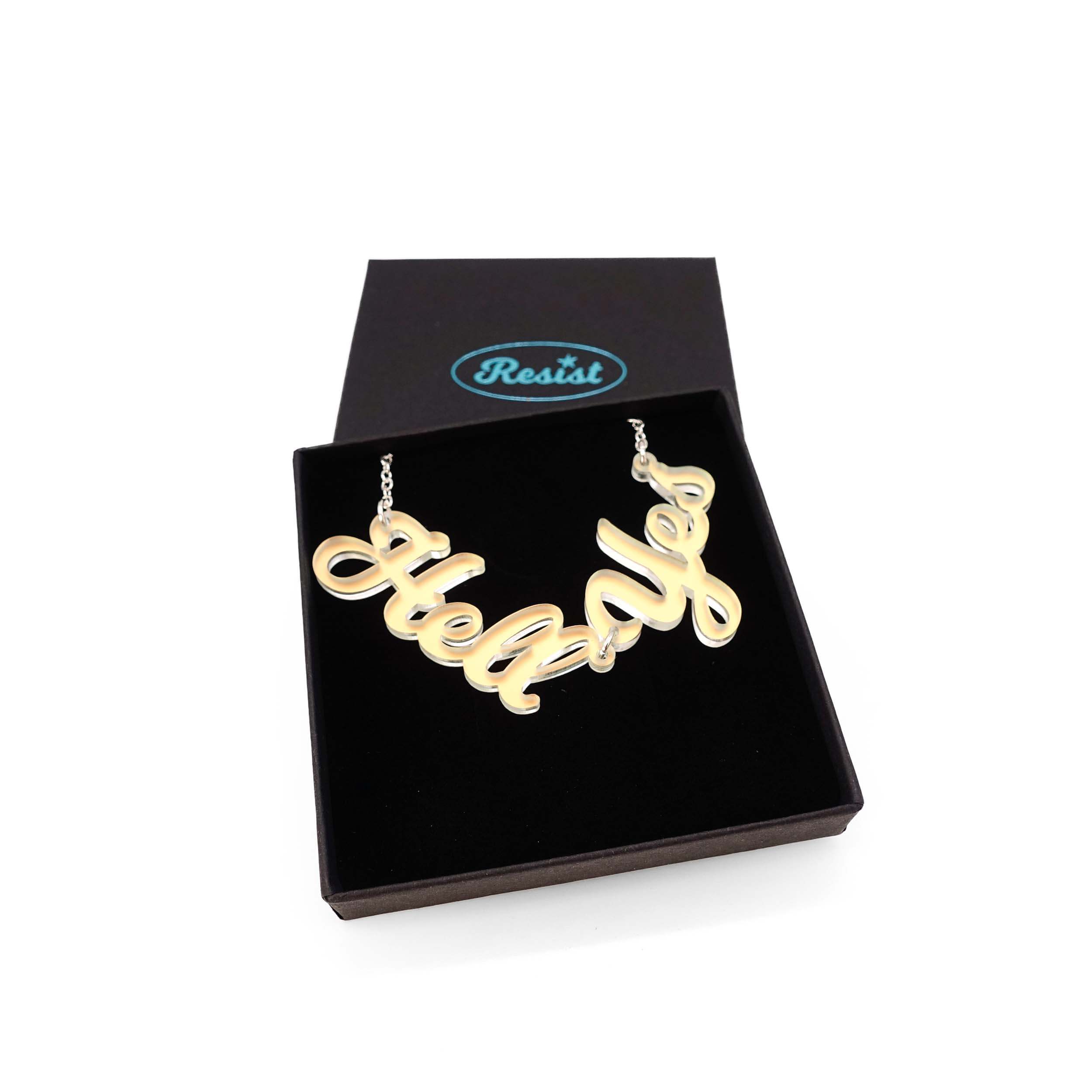 Hell Yes necklace in matte iridescent, shown in a Wear and Resist gift box.