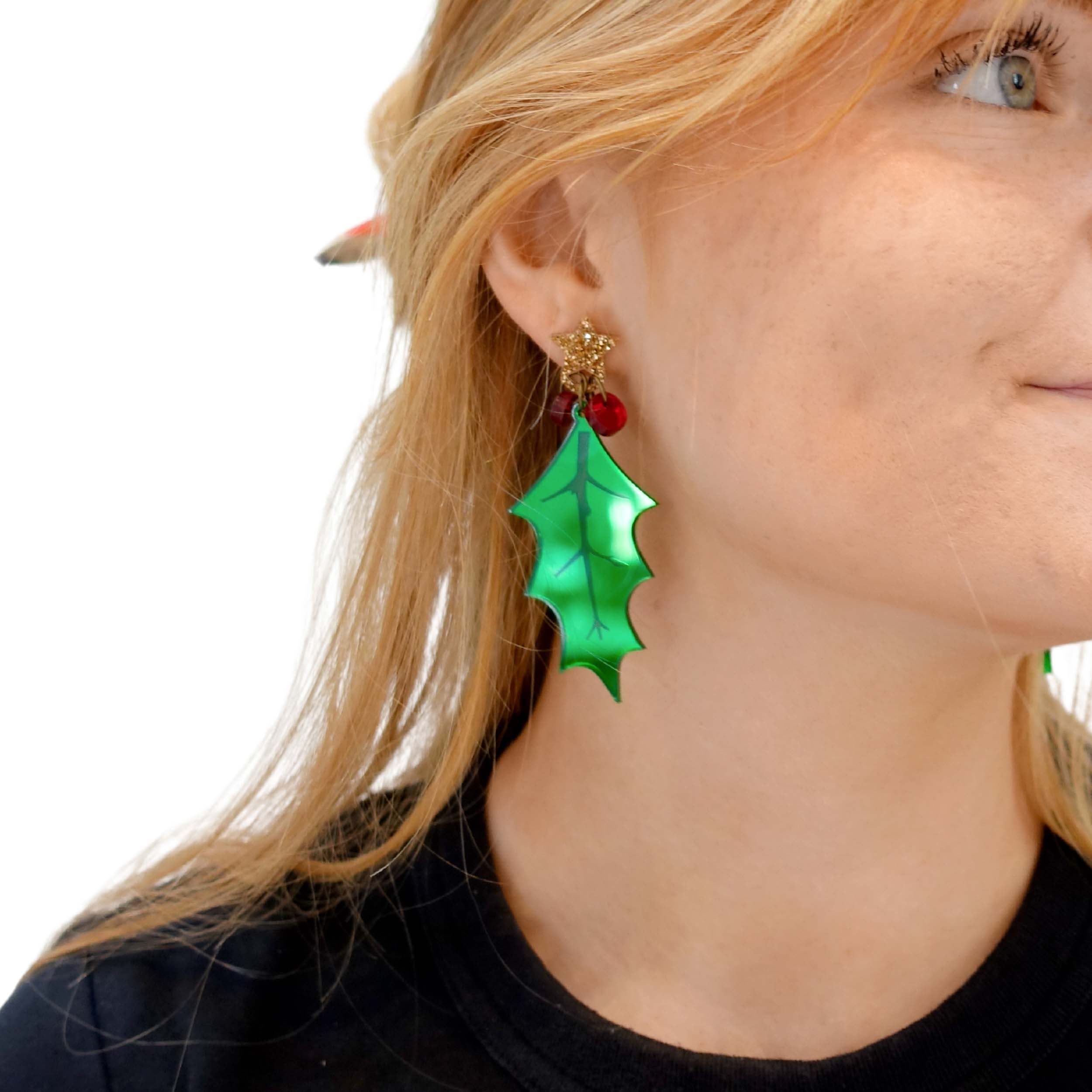 A close up of Eliza wearing the Statement Holly earrings with gold glitter star top.