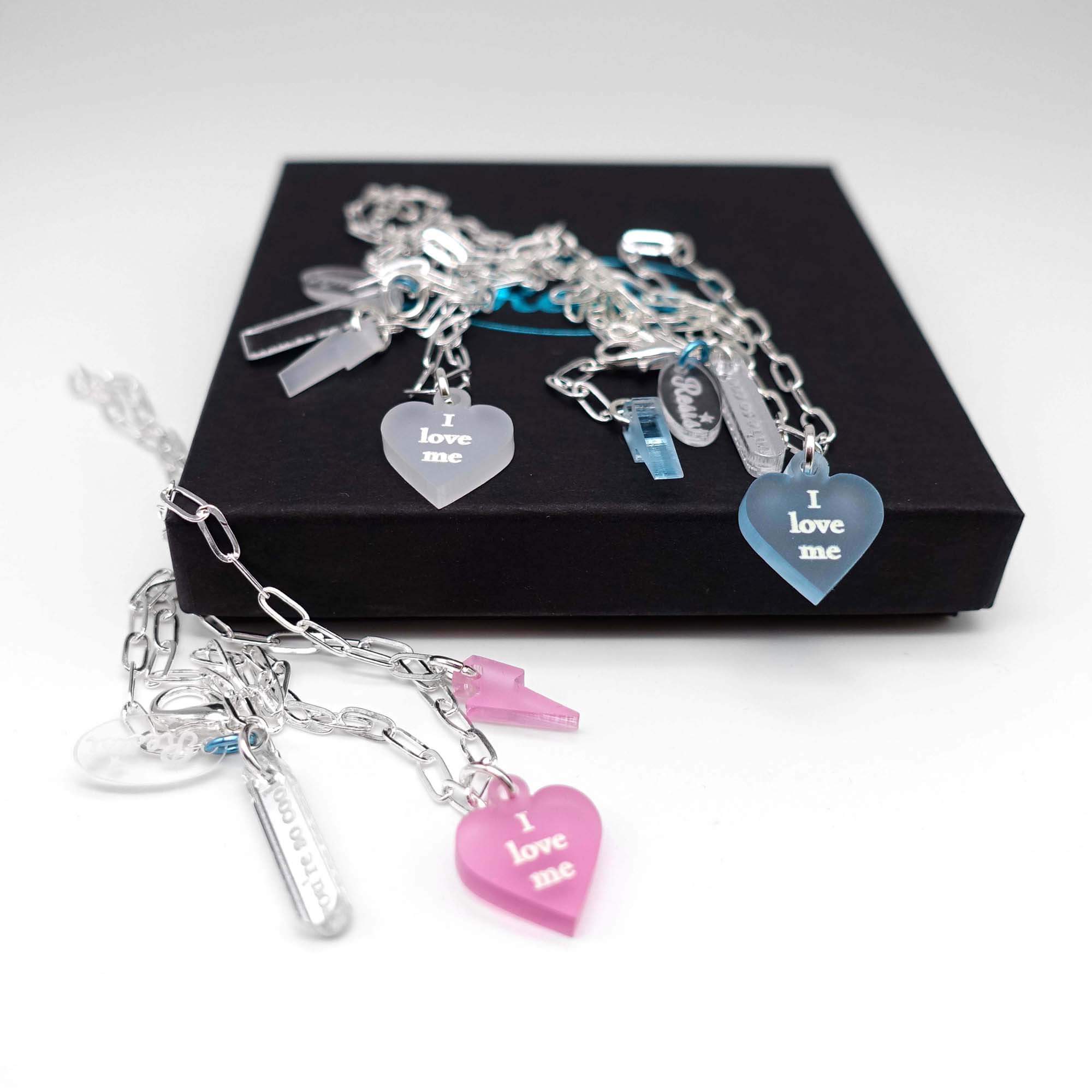 I love me glow in the dark choker and bracelet in all three colours, shown on a Wear and Resist gift box.