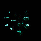 I Love Me heart drop earrings shown in the dark with the words I LOVE ME glowing. Three words you should say to yourself every day!