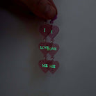 I Love Me heart drop earrings in pale pink frost with shown glowing in the dark.