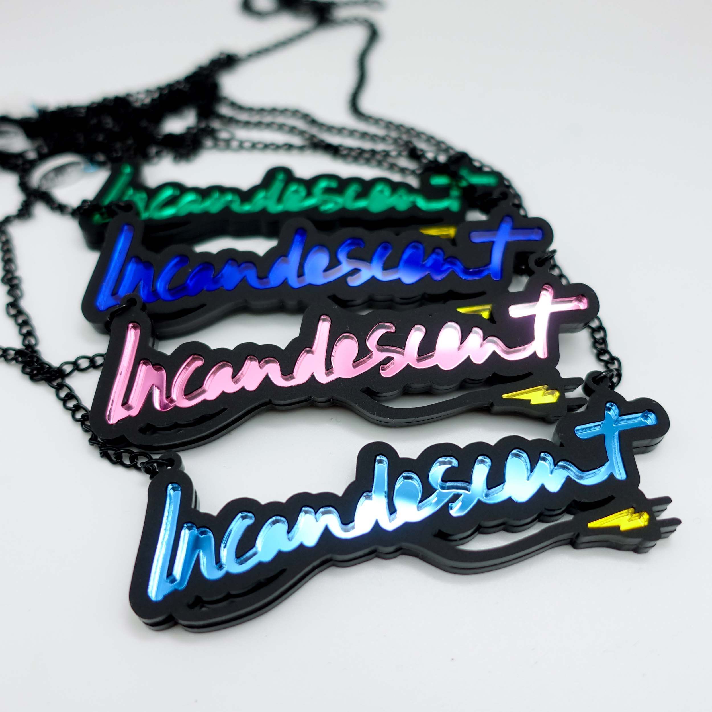 A group shot showing the four colours of Incandescent neon necklaces, electric green, electric blue, pink and sky blue, all finished with a yellow mirror lightning bolt plug.