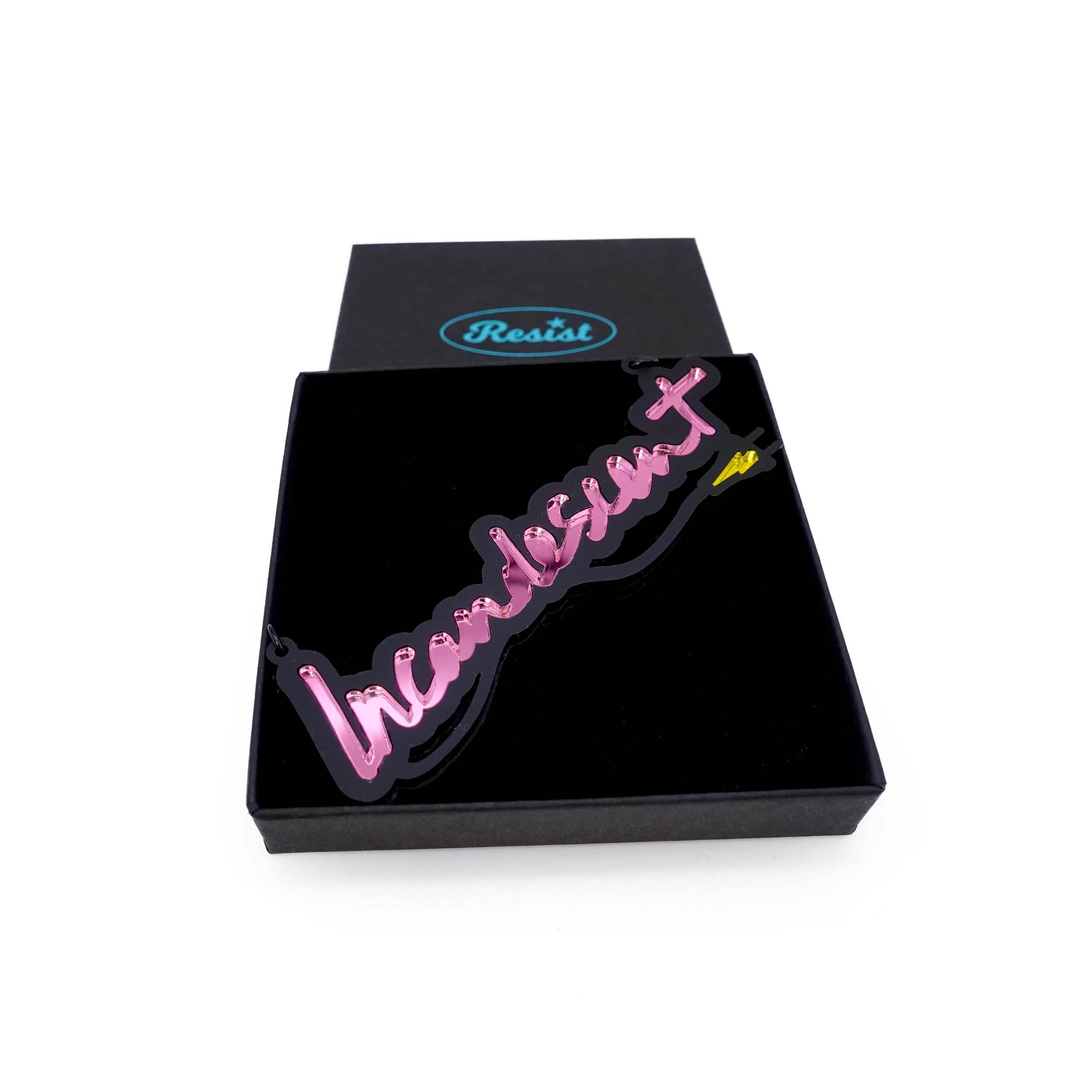 An Incandescent neon necklace in pink shown in a Wear and Resist gift box.