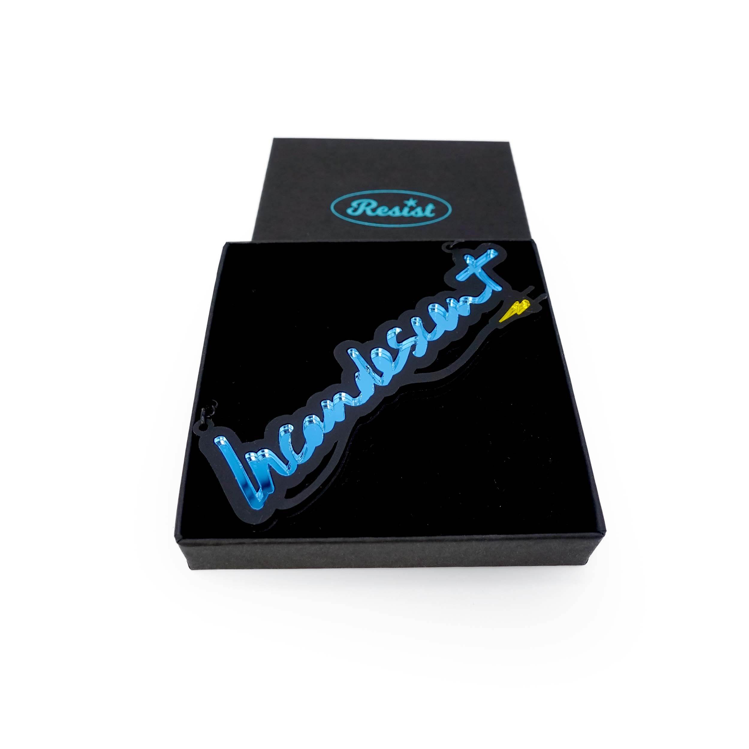 An Incandescent neon necklace in sky blue shown in a Wear and Resist gift box.
