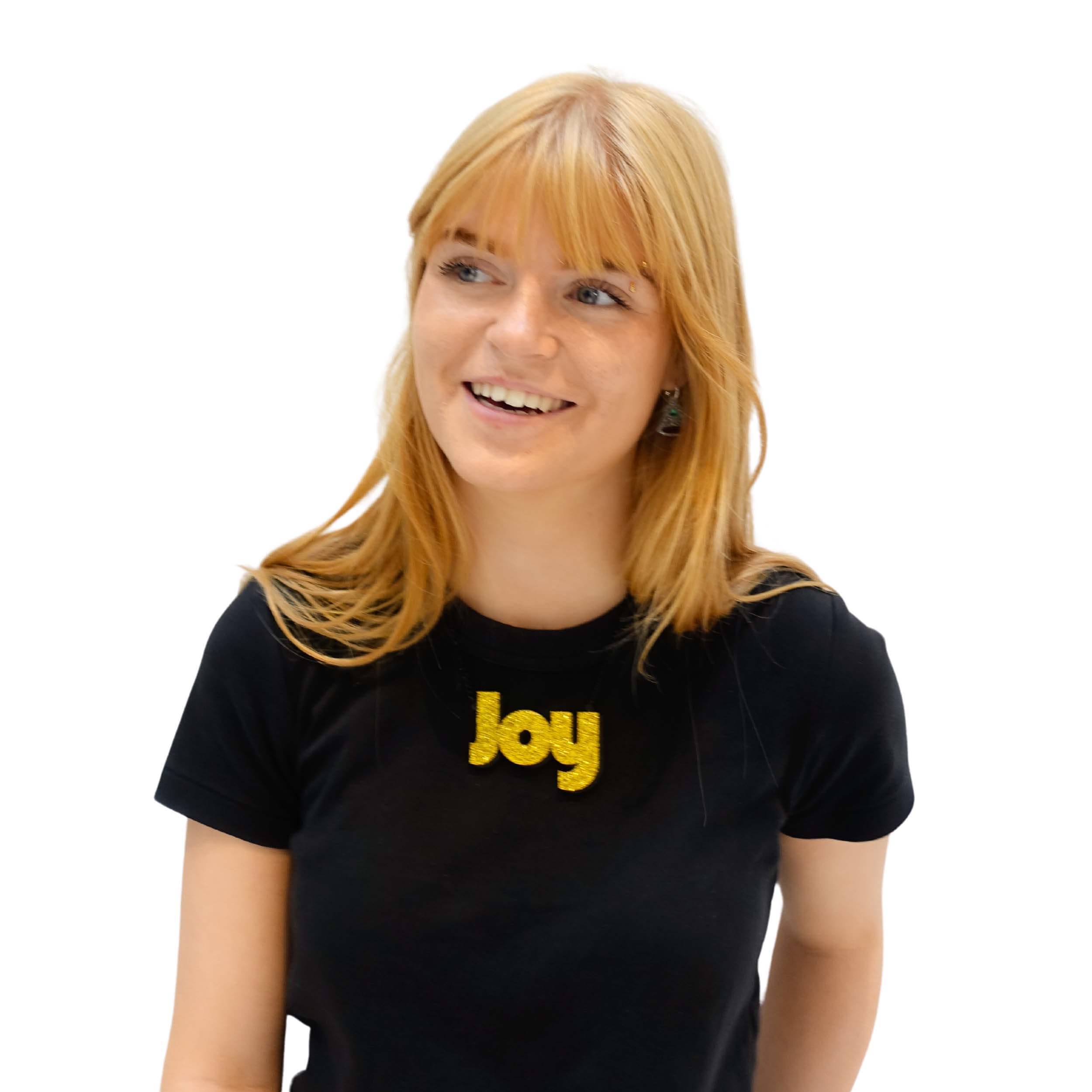 Eliza laughs wearing a Joy statement necklace in ultra gold glitter.