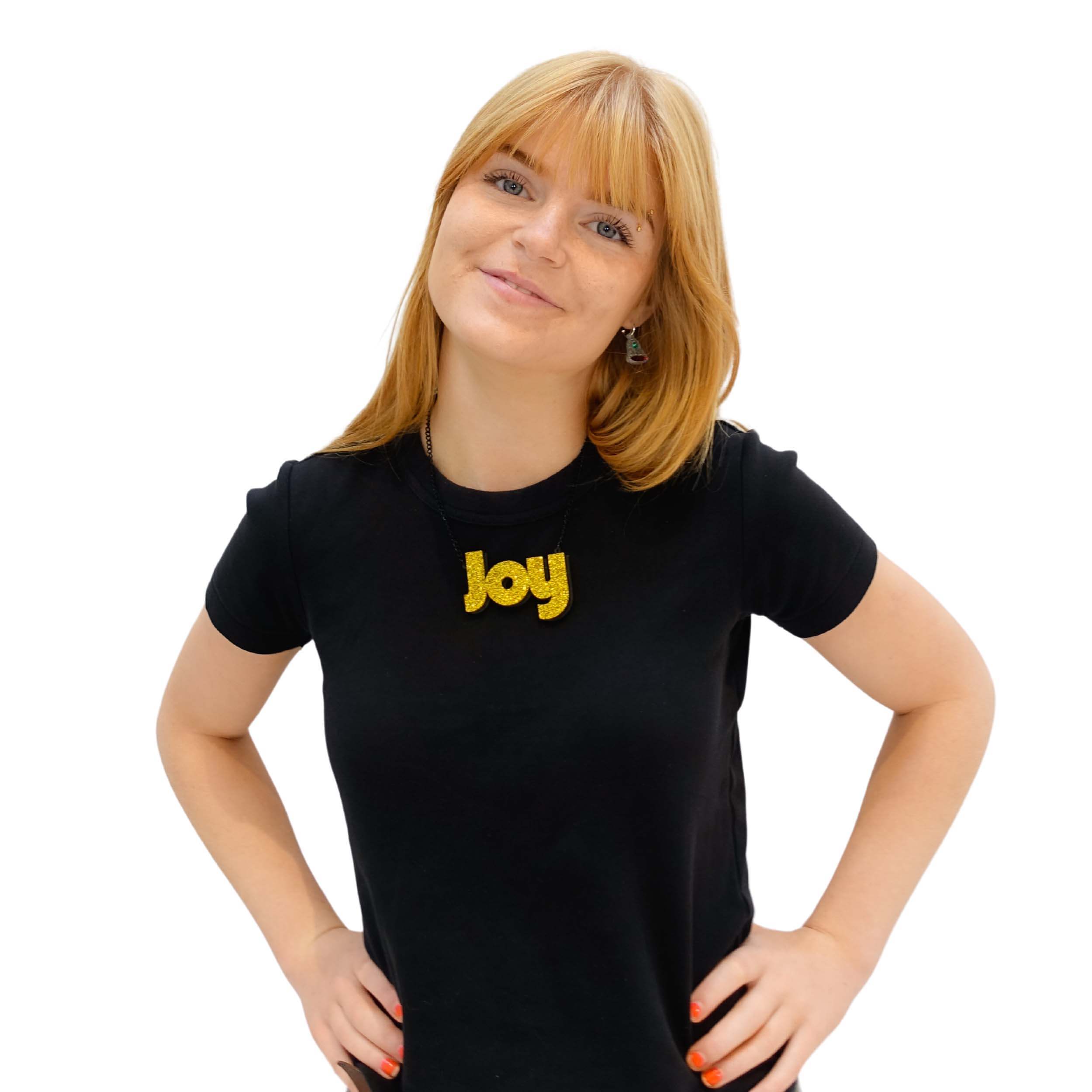 Eliza wears a Joy statement necklace in ultra gold glitter. New this year for the Christmas Collection at Wear and Resist.