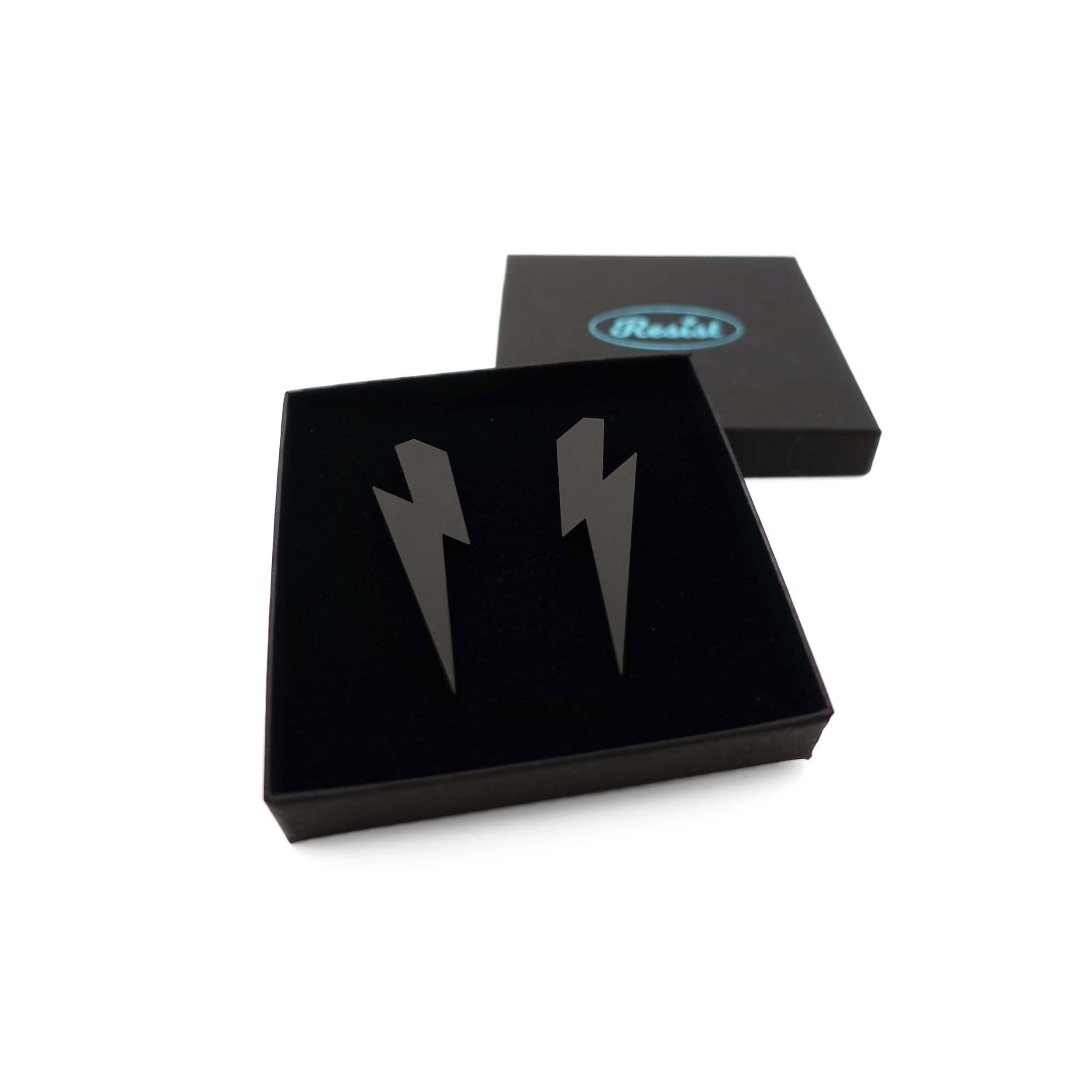 Large Lightning Bolt earrings in matte black, shown in a Wear and Resist gift box.