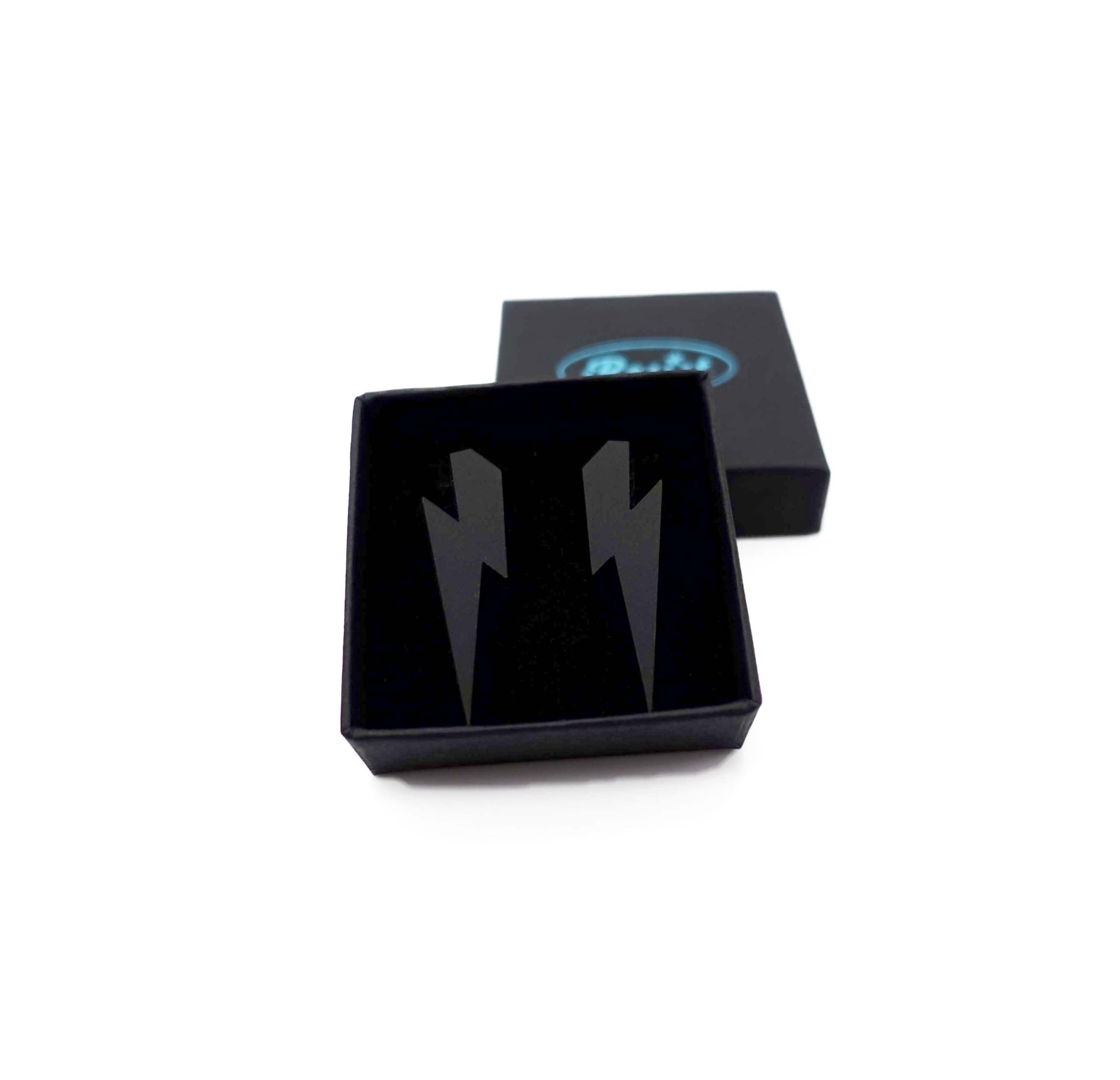 Medium Lightning Bolt earrings in matte black, shown in a small Wear and Resist gift box.