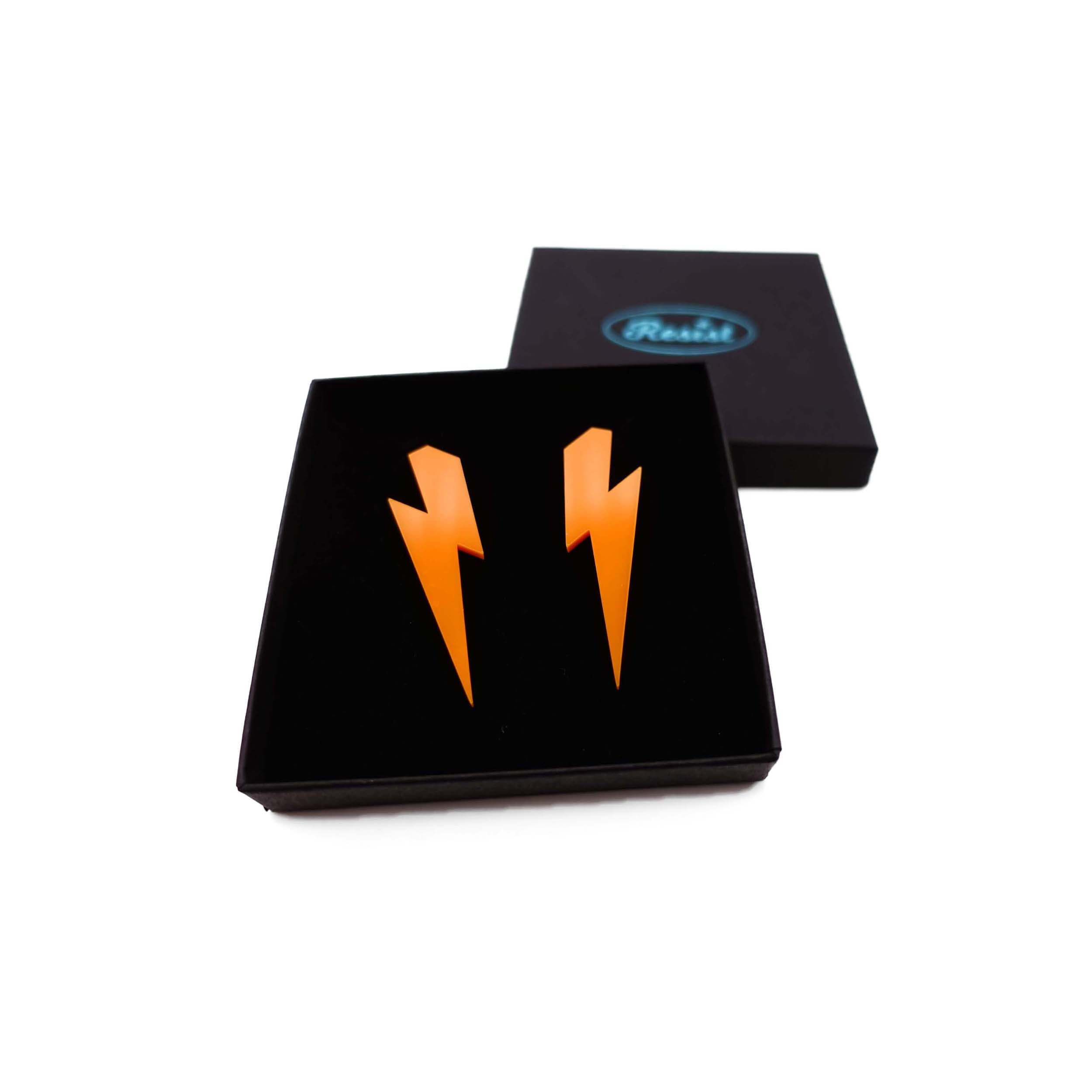 Large Lightning Bolt earrings in orange, shown in a Wear and Resist gift box.