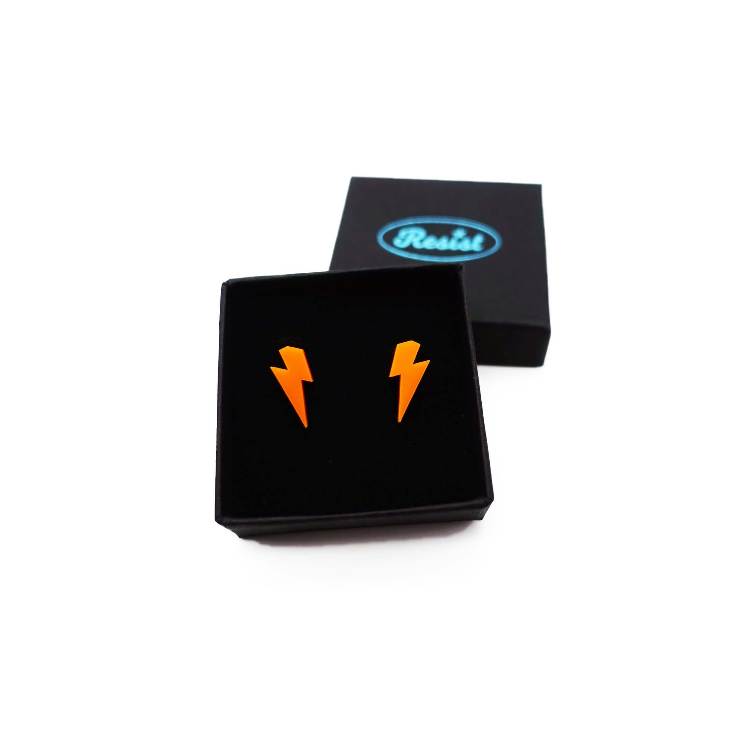 Tiny Lightning Bolt earrings in orange, shown in a small Wear and Resist gift box.