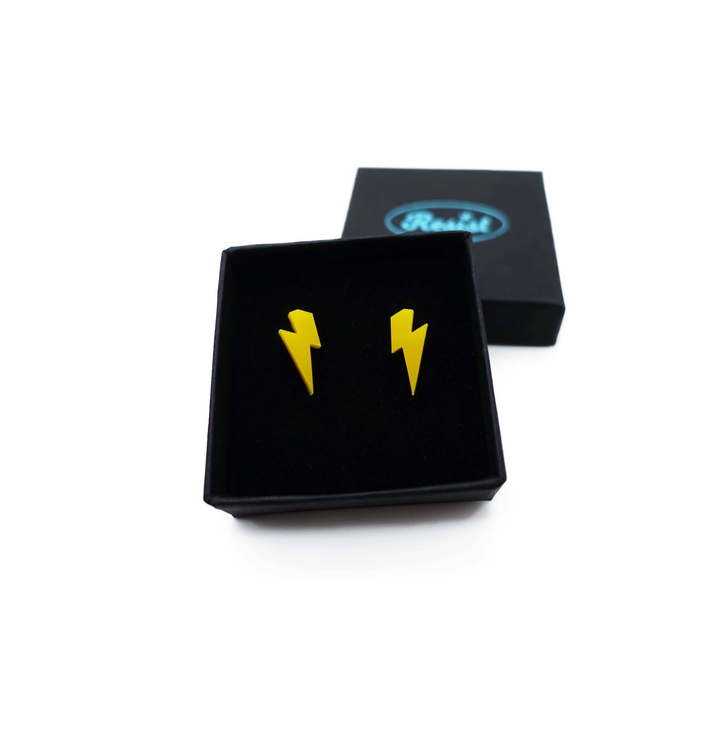 Tiny Lightning Bolt earrings in sunflower yellow, shown in a small Wear and Resist gift box.