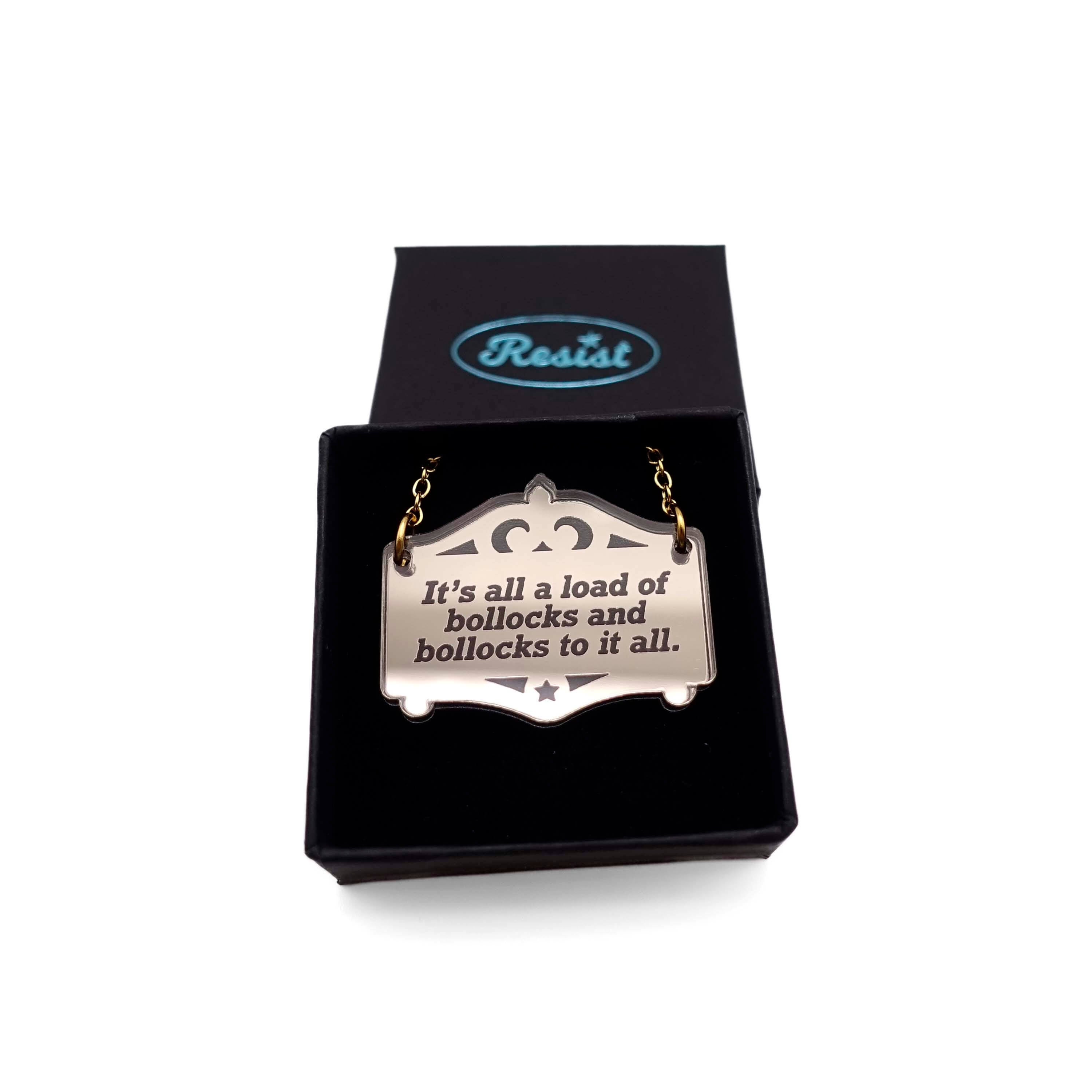 The lyrics of the Specials immortalised on a bronze Mirror Cowboy necklace: It's all a load of bollocks and bollocks to it all. Shown in a small Wear and Resist gift box.