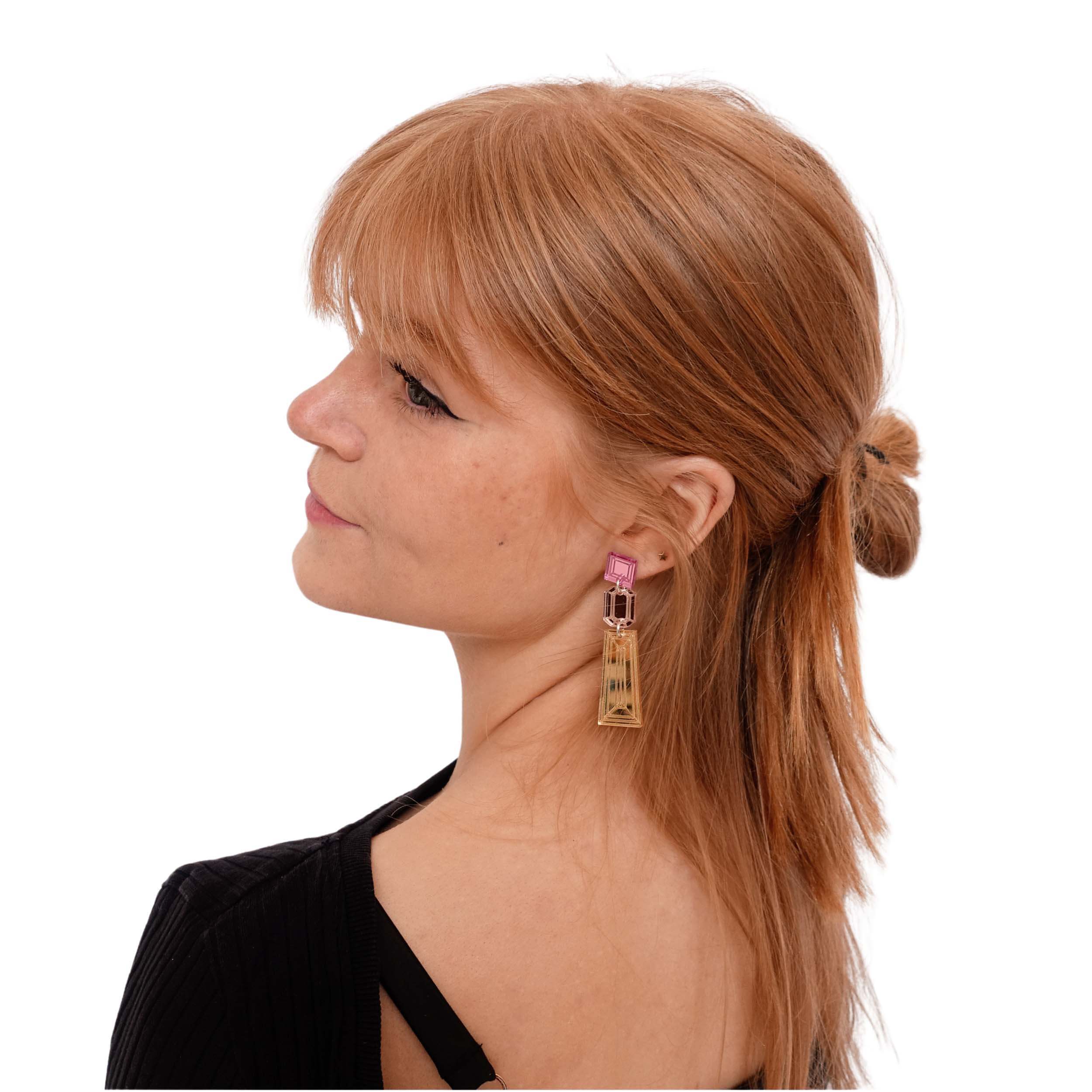 Eliza wears gold, rose gold and pink Deco Drop long earrings.
