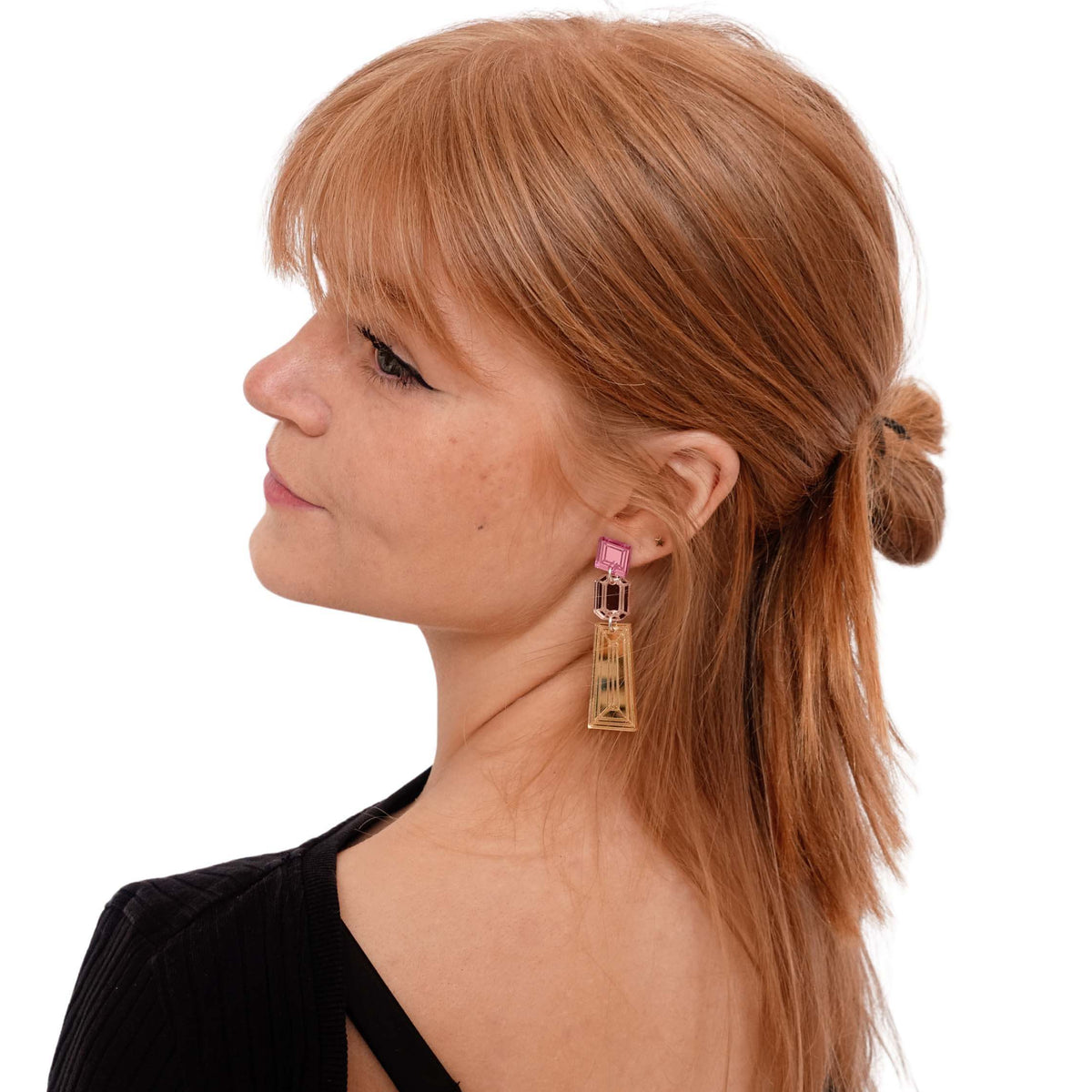 Eliza wears gold, rose gold and pink Deco Drop long earrings.